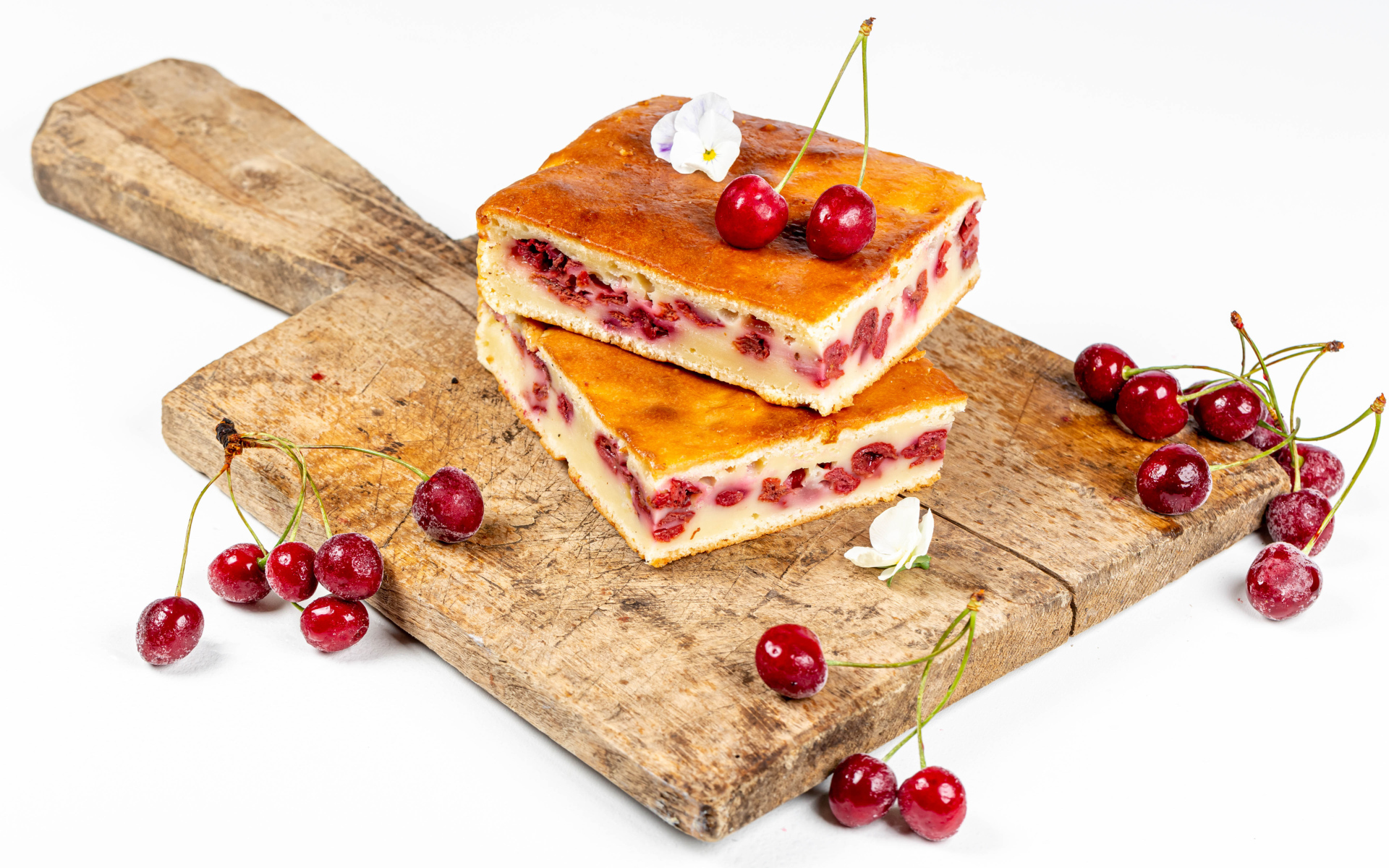 Пирог с вишнями на доске на белом фоне