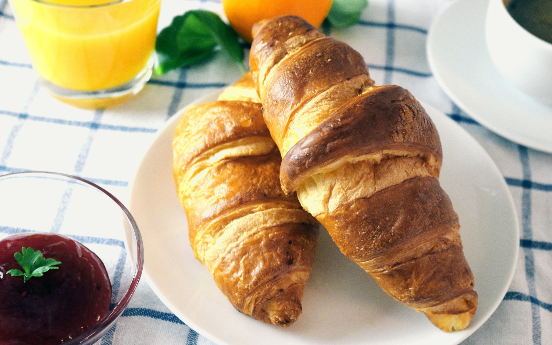 Два круассана на столе с джемом и соком