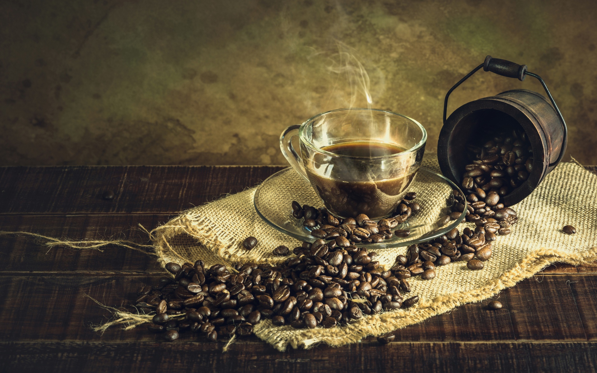 Чашка горячего крепкого кофе на столе с зернами