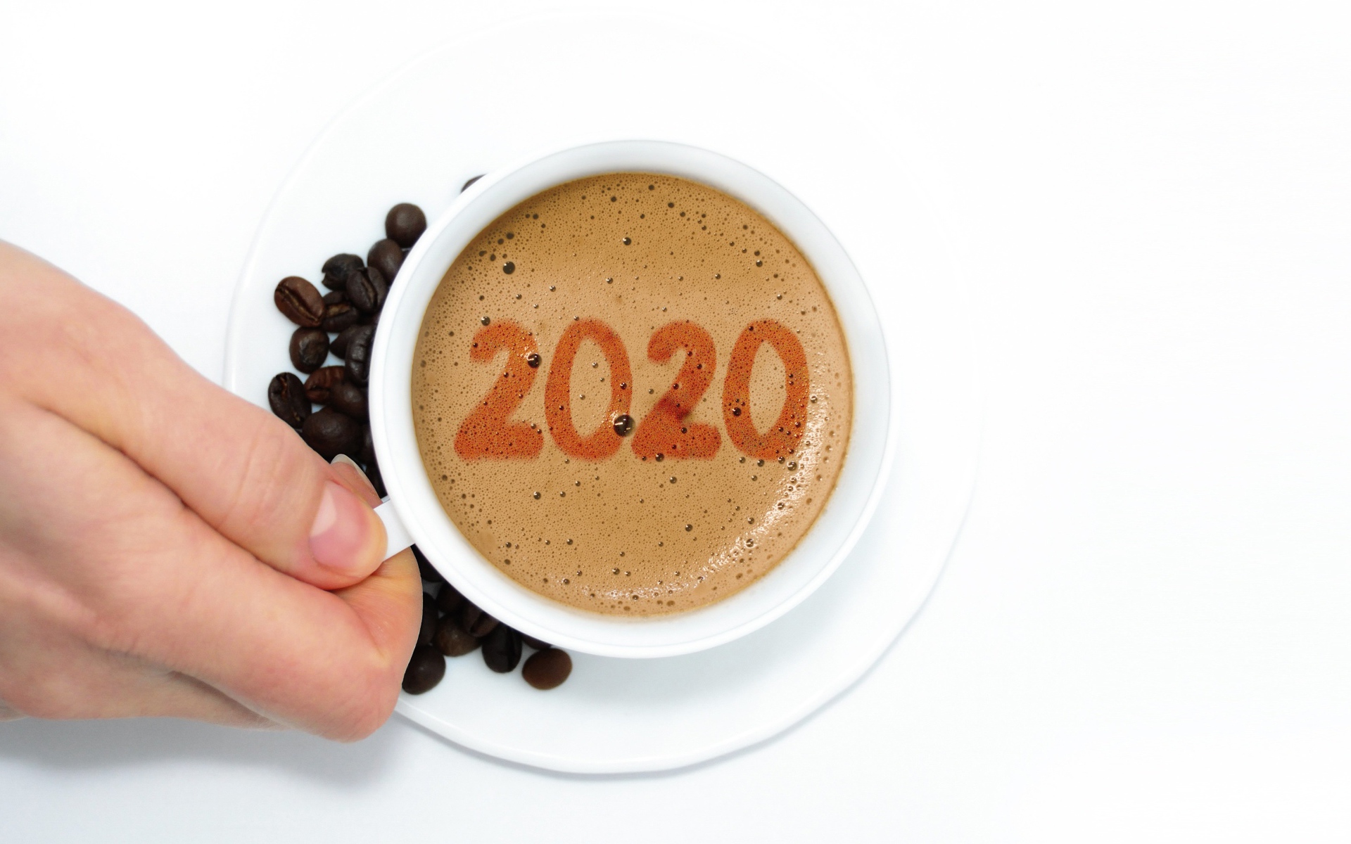 Чашка кофе в руке на белом столе с зернами
