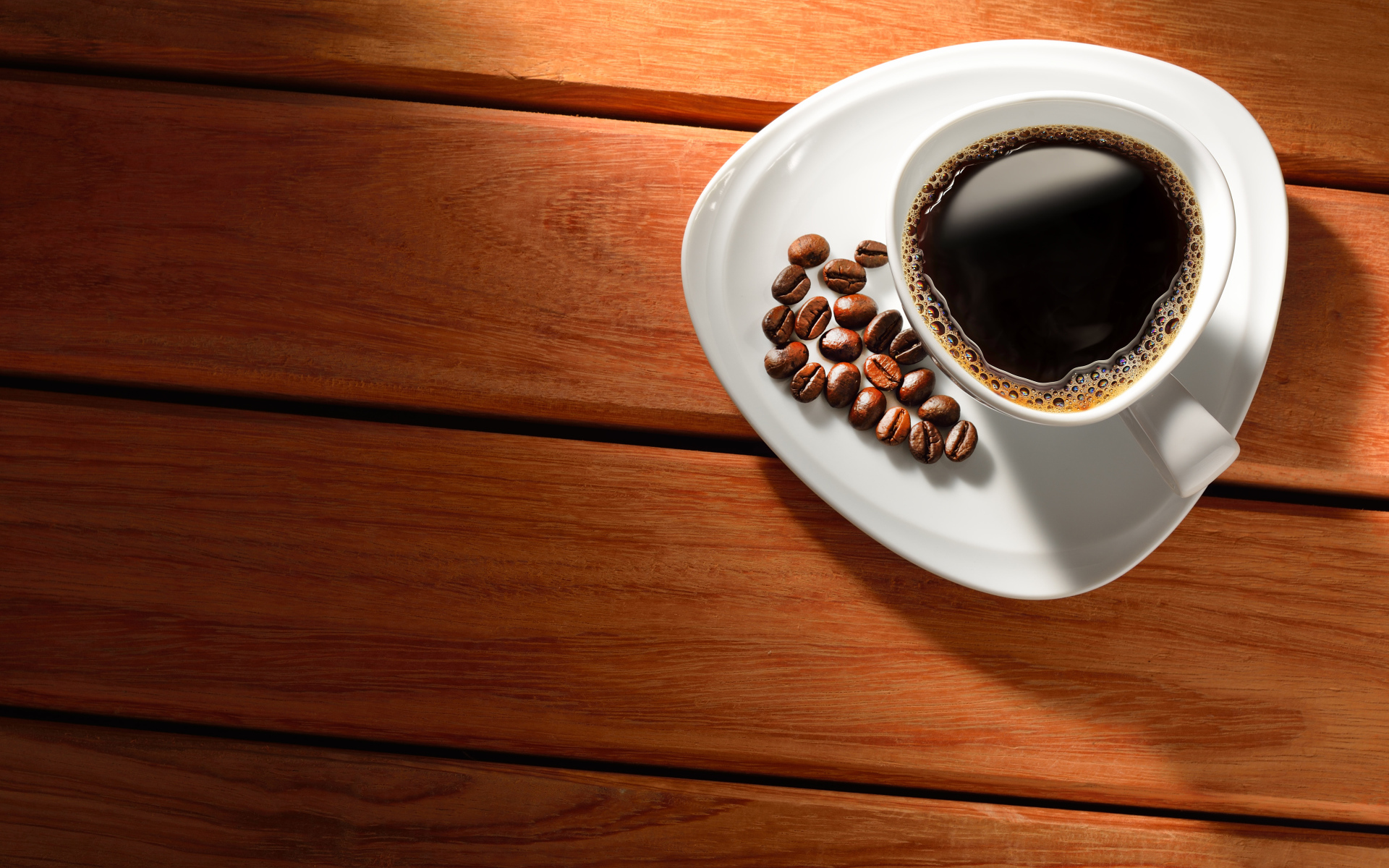 Чашка кофе на тарелке с зернами на деревянном столе