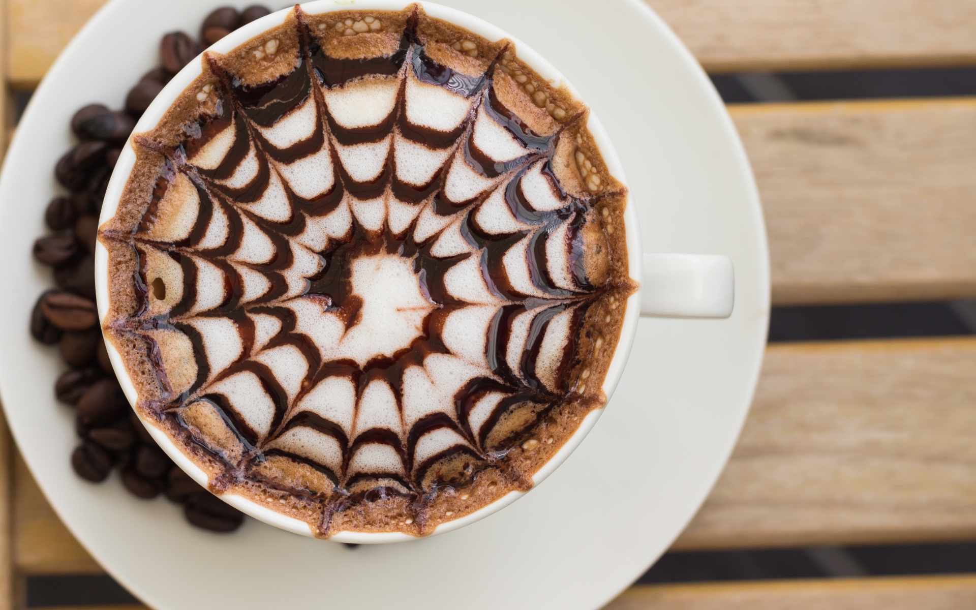 Чашка кофе с рисунком на пене на столе