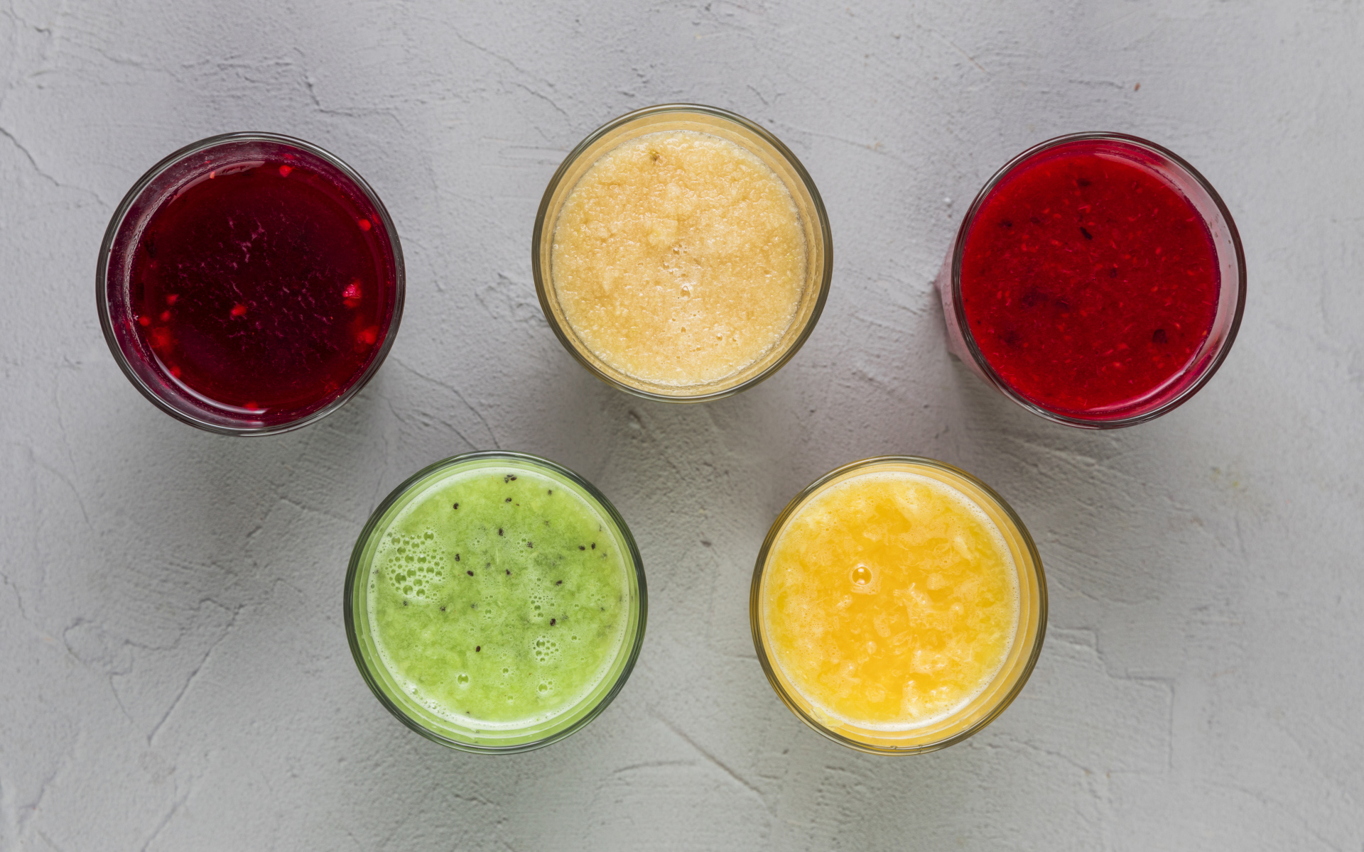 Стаканы с вкусным смузи на сером фоне