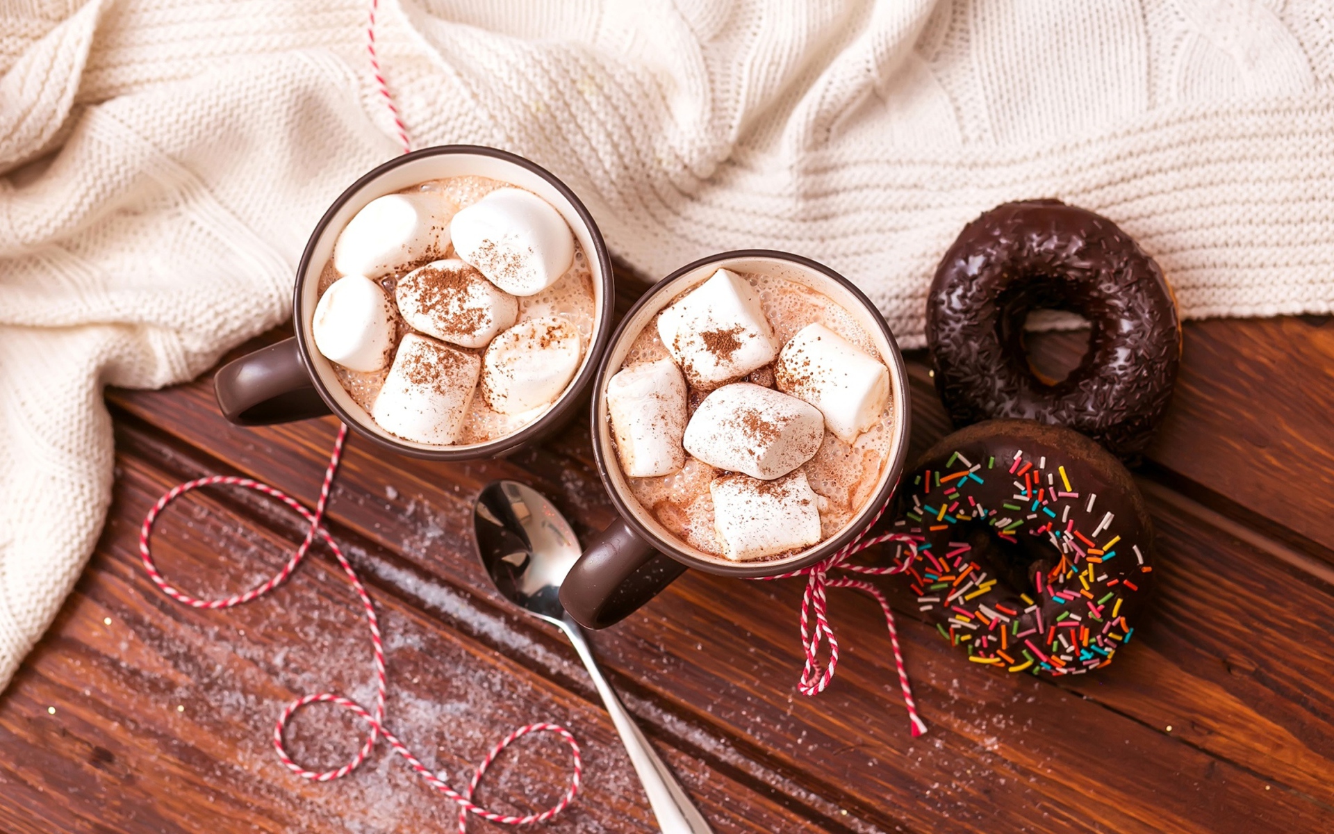 Горячий какао с маршмеллоу с пончиками на столе 