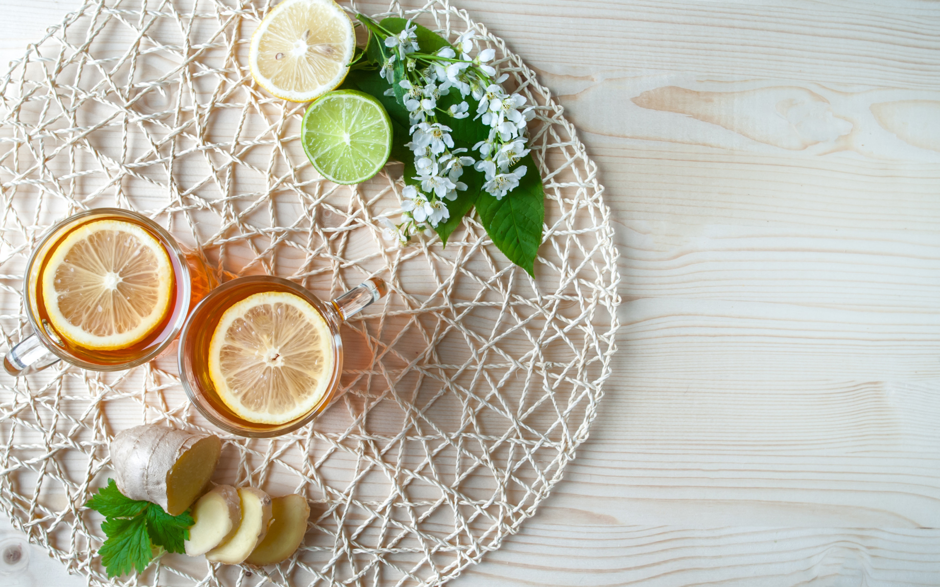 Две чашки чая с лимоном на плетеной подставке 