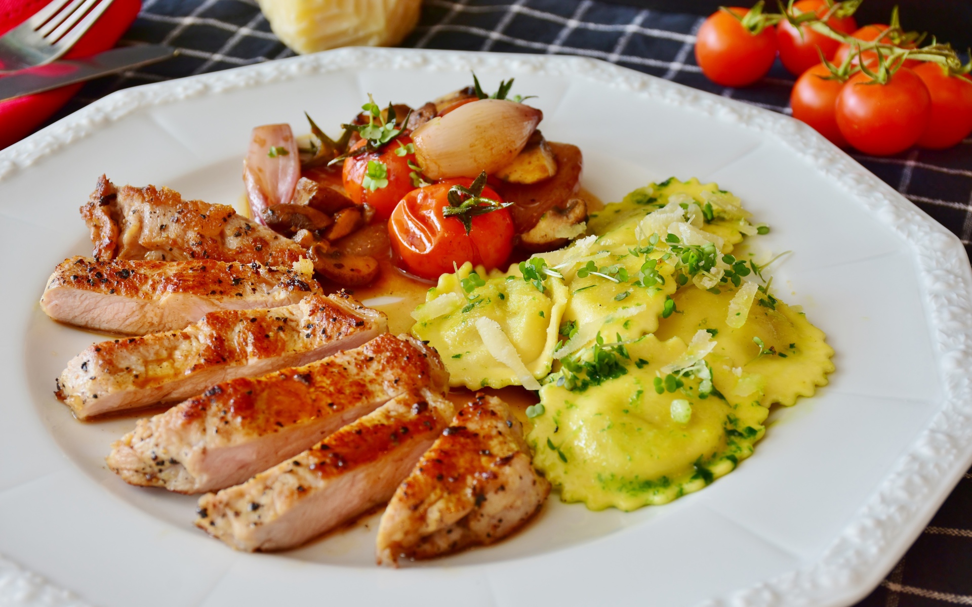 Куриное филе нарезанное кусочками на тарелке с овощами и варениками