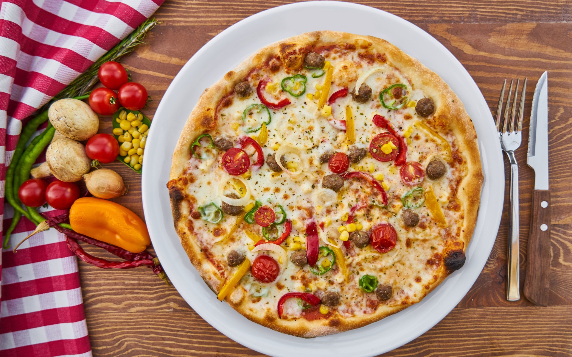 Аппетитная вкусная пицца на столе с овощами 