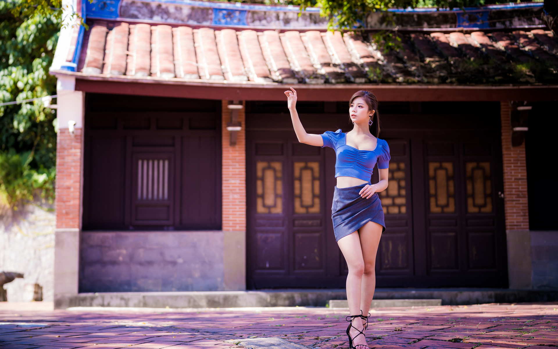 Девушка азиатка в короткой юбке у здания 