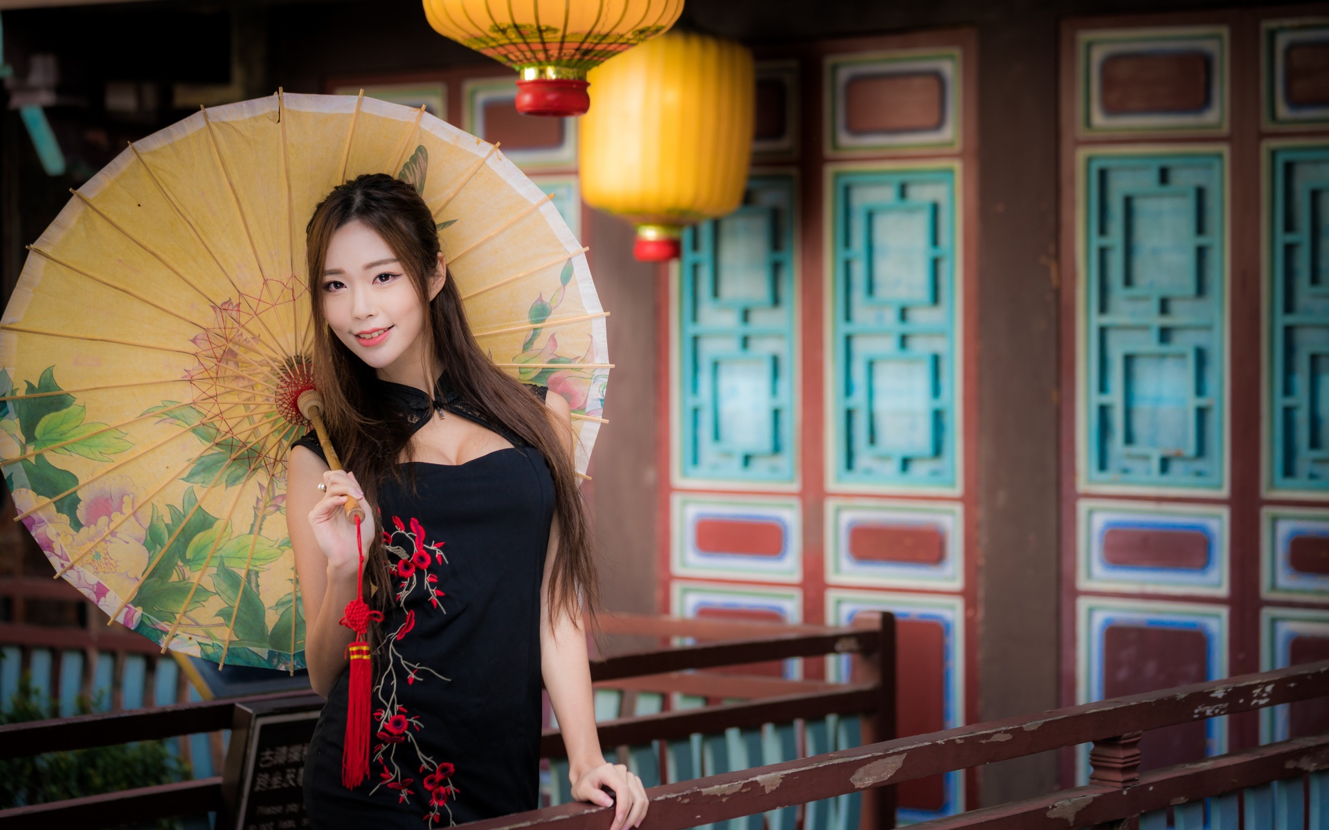 Красивая девушка азиатка в черном платье с зонтом