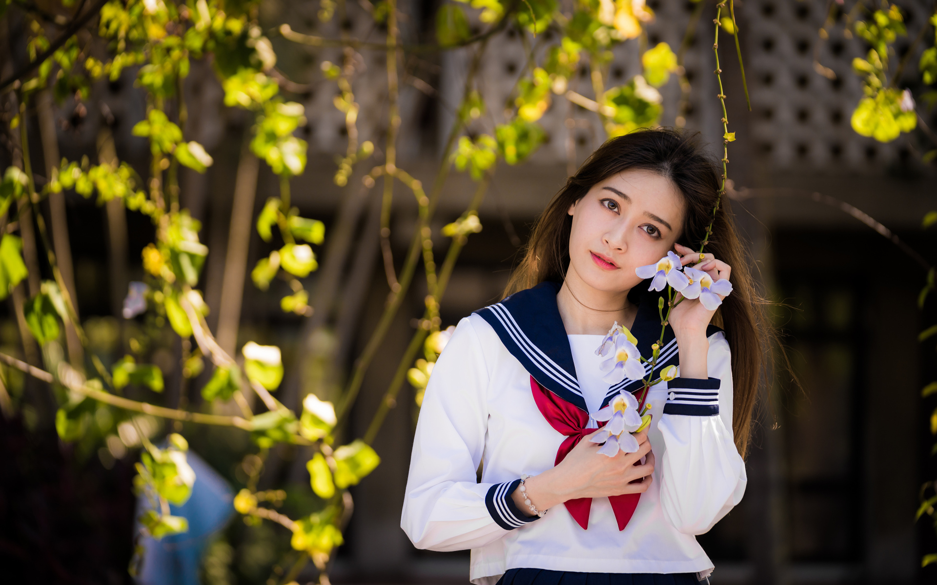 Красивая девушка азиатка в форме с цветами в руках 