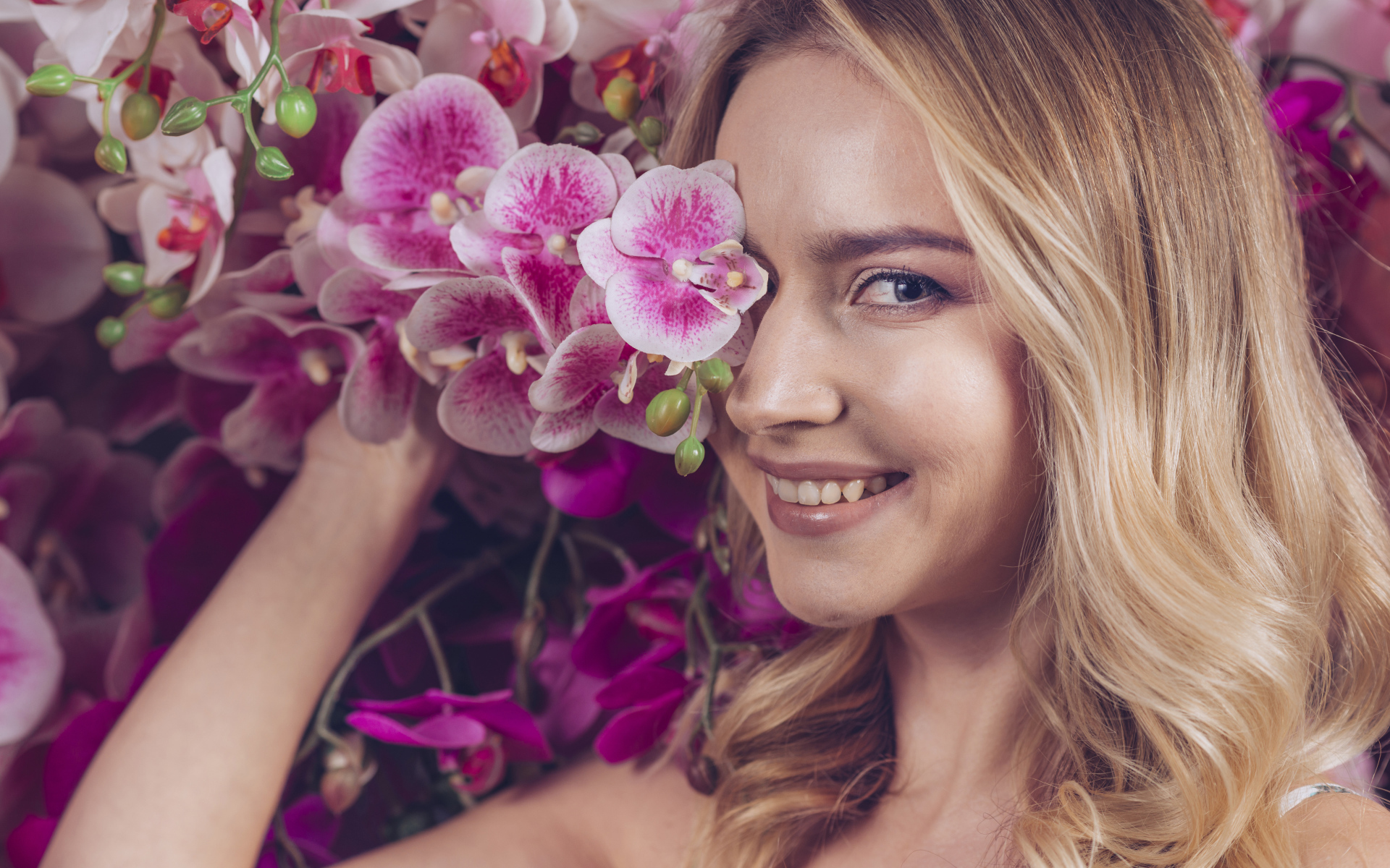 Красивая девушка блондинка с цветами орхидеи