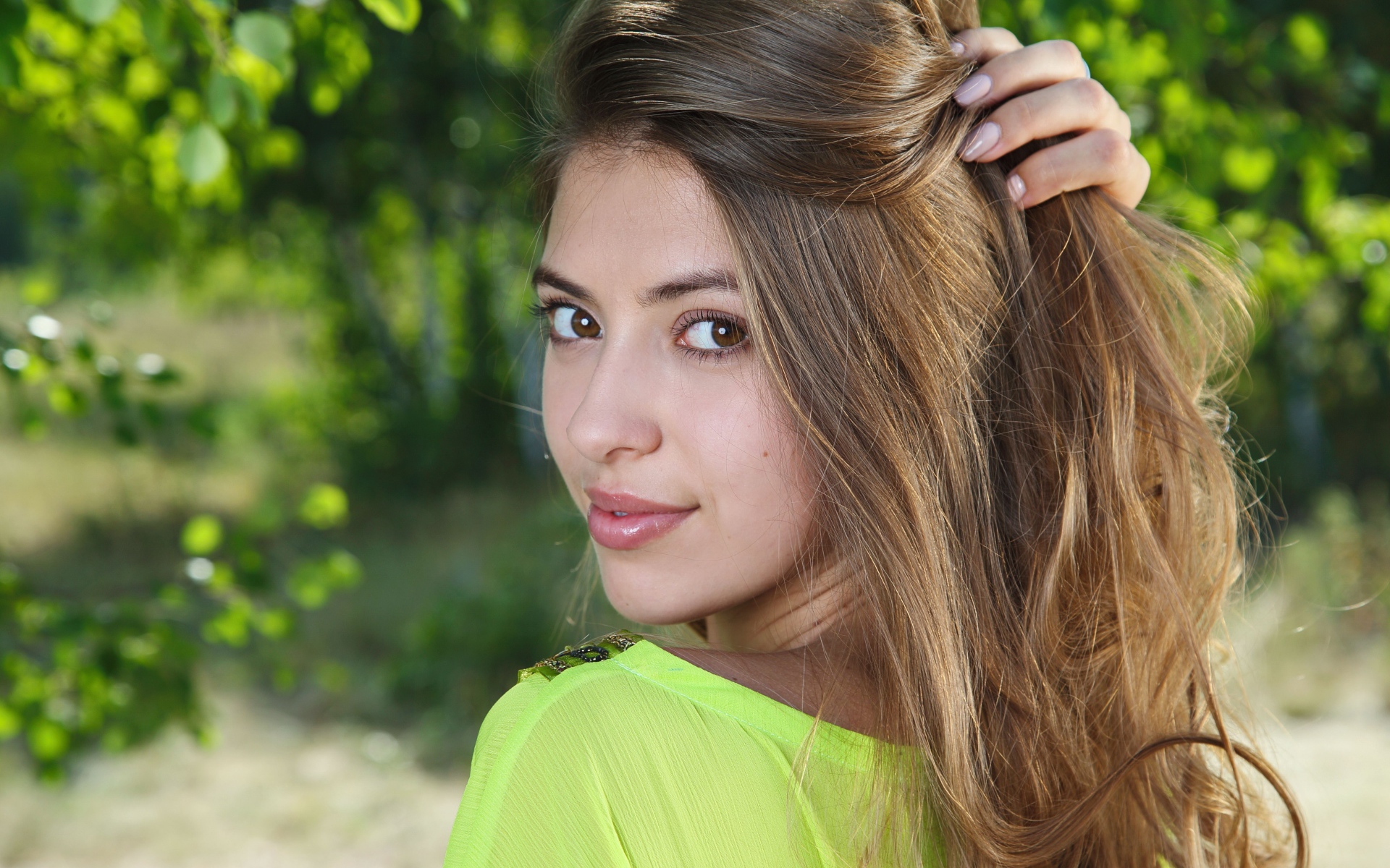 Красивая кареглазая шатенка с рукой в волосах 