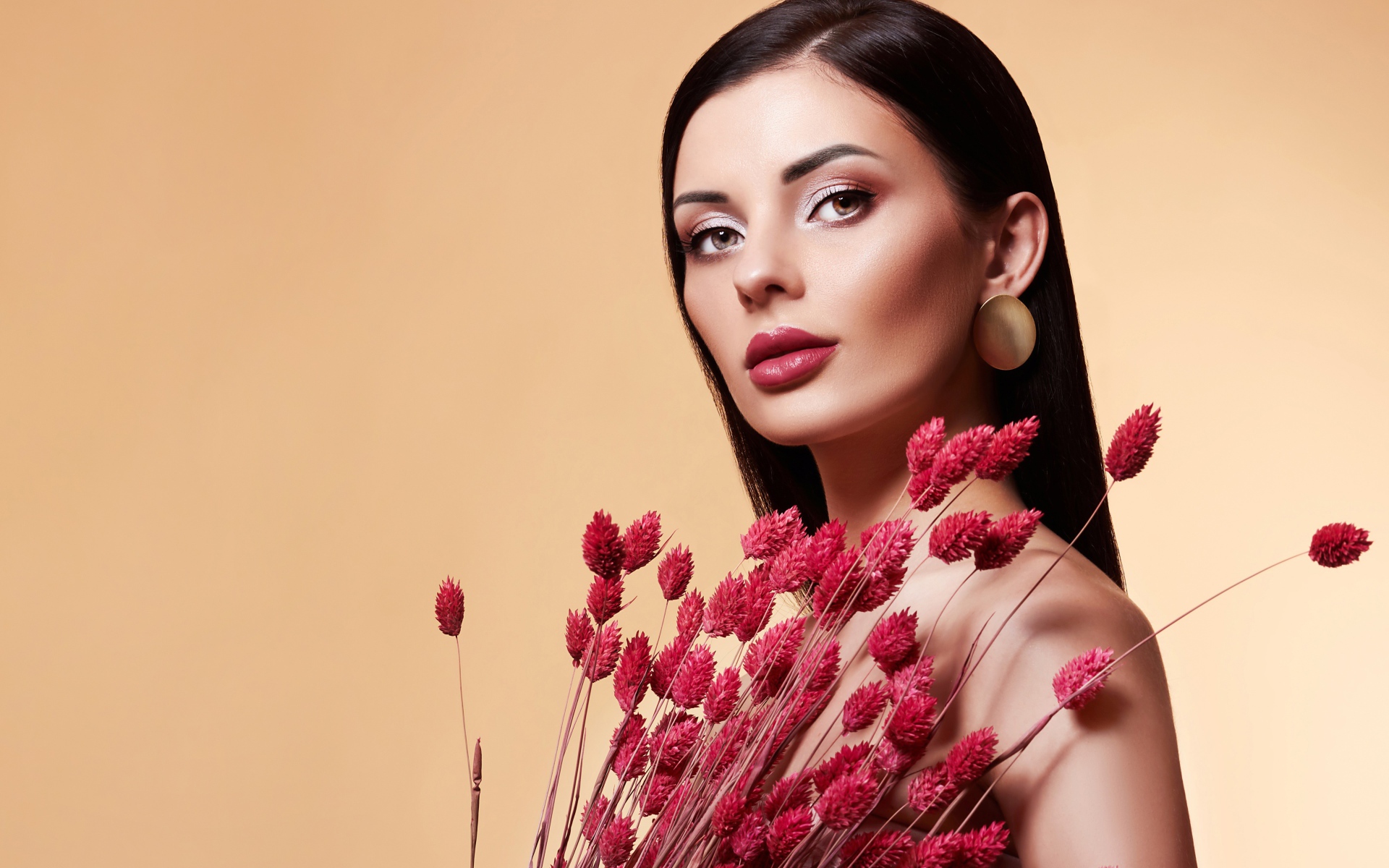 Красивая брюнетка в букетом красных цветов 