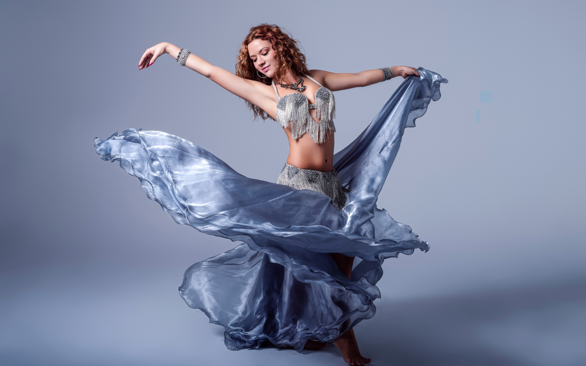 Красивая девушка в платье для танцев на сером фоне