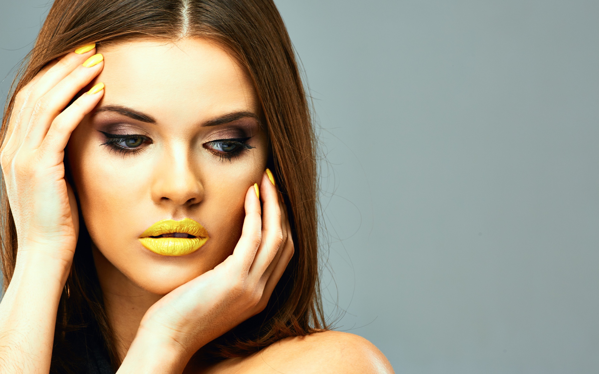 Красивая девушка с желтыми губами на сером фоне