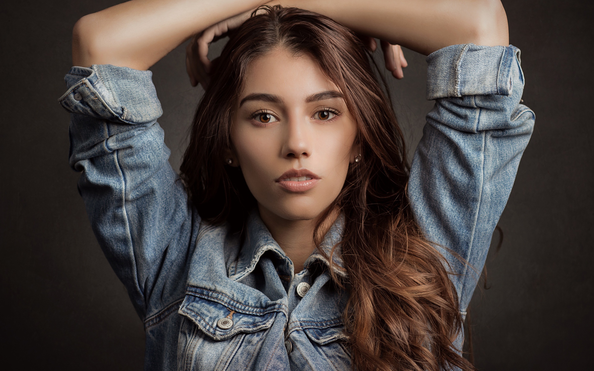 Красивая длинноволосая шатенка в джинсовой куртке 