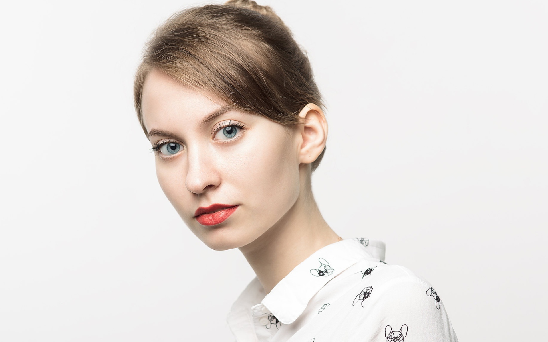 Милая голубоглазая девушка в рубашке на сером фоне