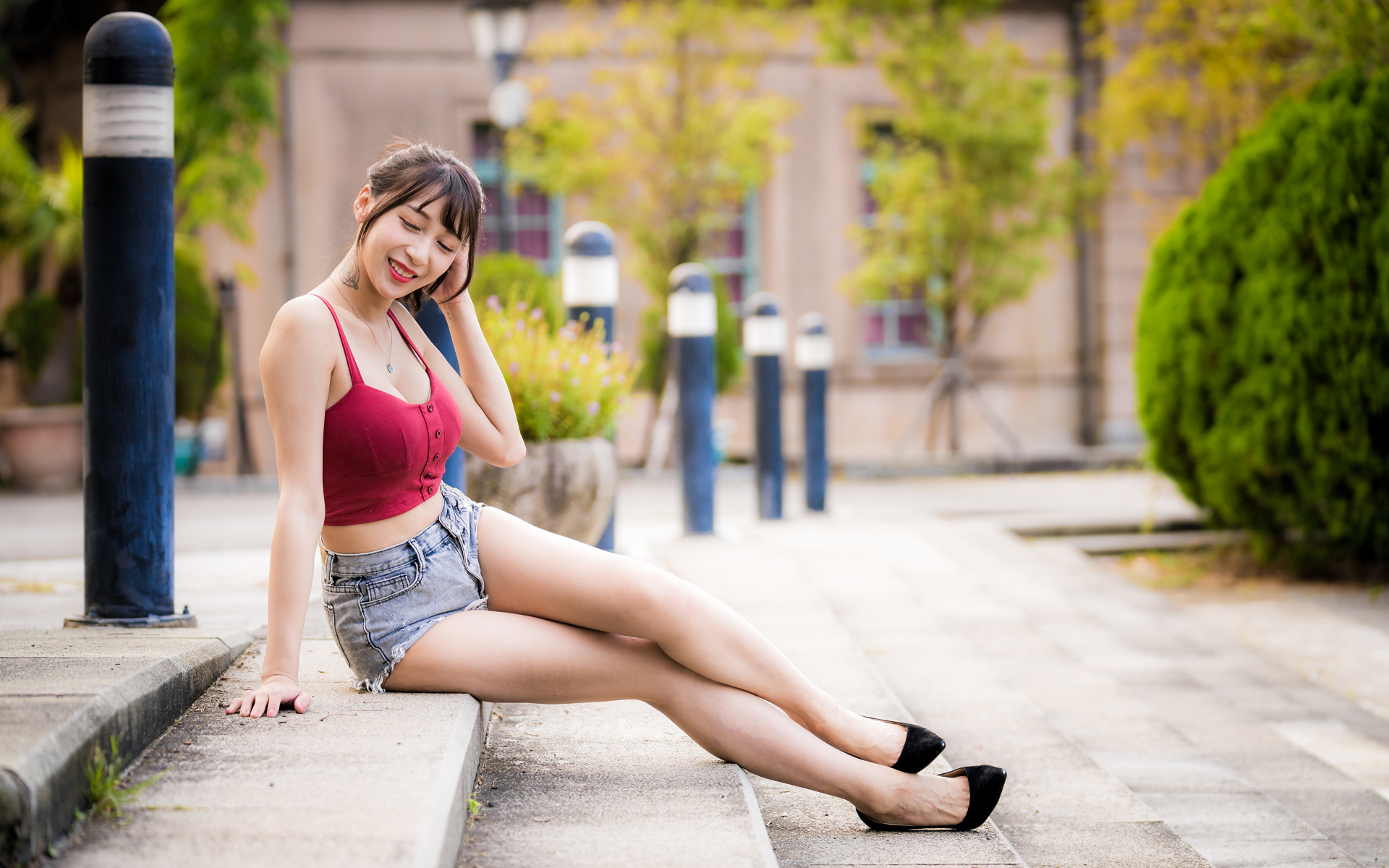 Милая улыбающаяся девушка азиатка сидит на ступенях