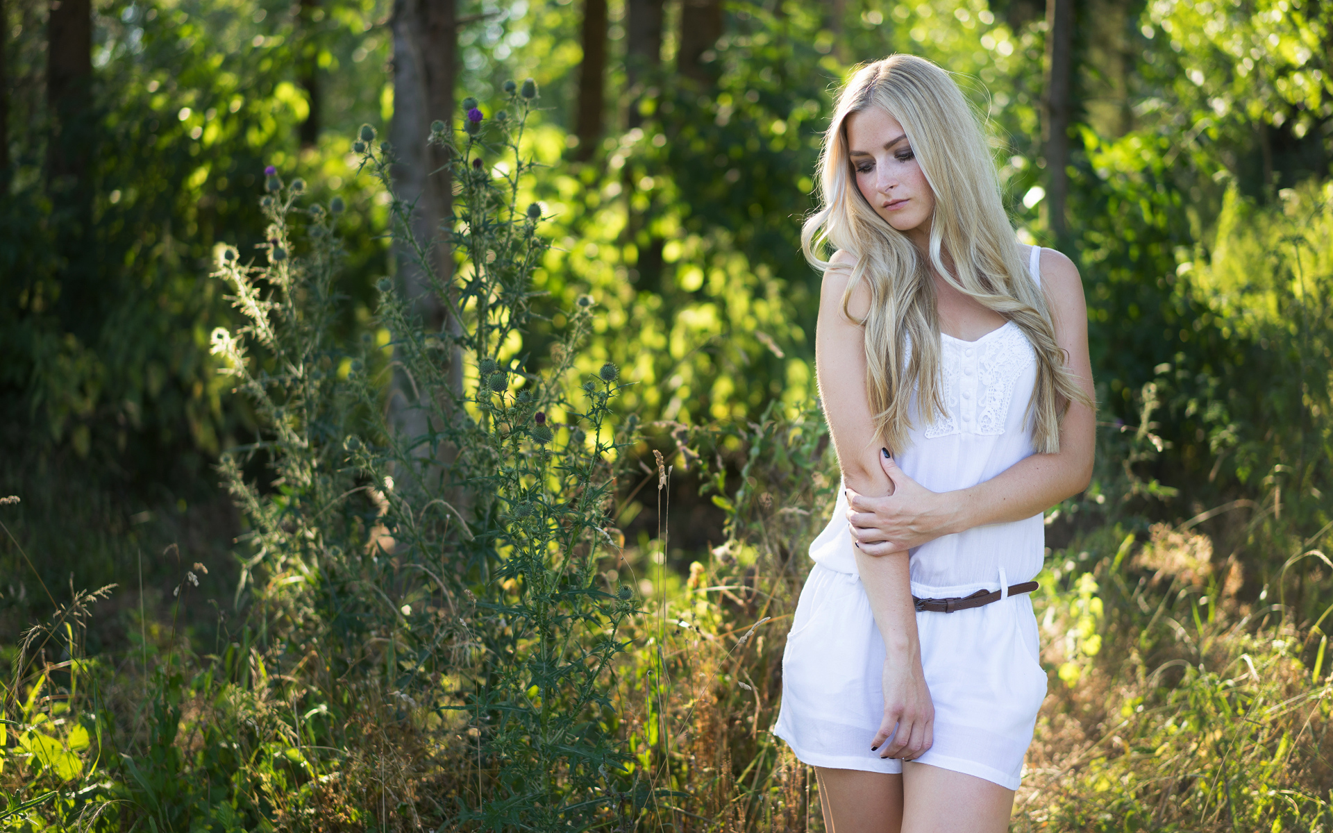 Нежная блондинка в белом костюме в лесу