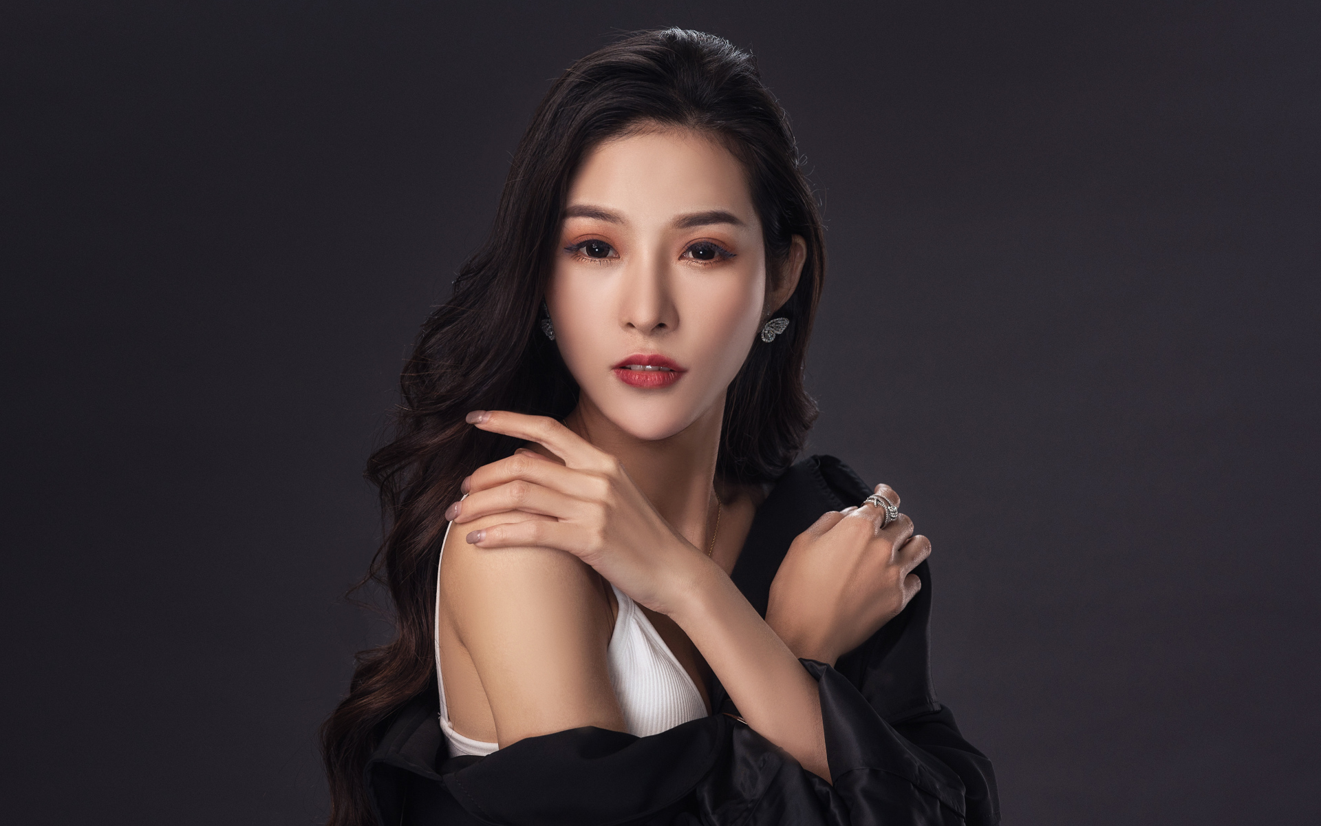Нежная длинноволосая азиатка на сером фоне