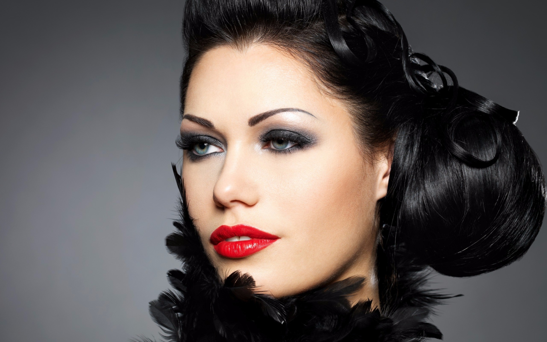 Лицо брюнетки с красивой прической на голове на сером фоне