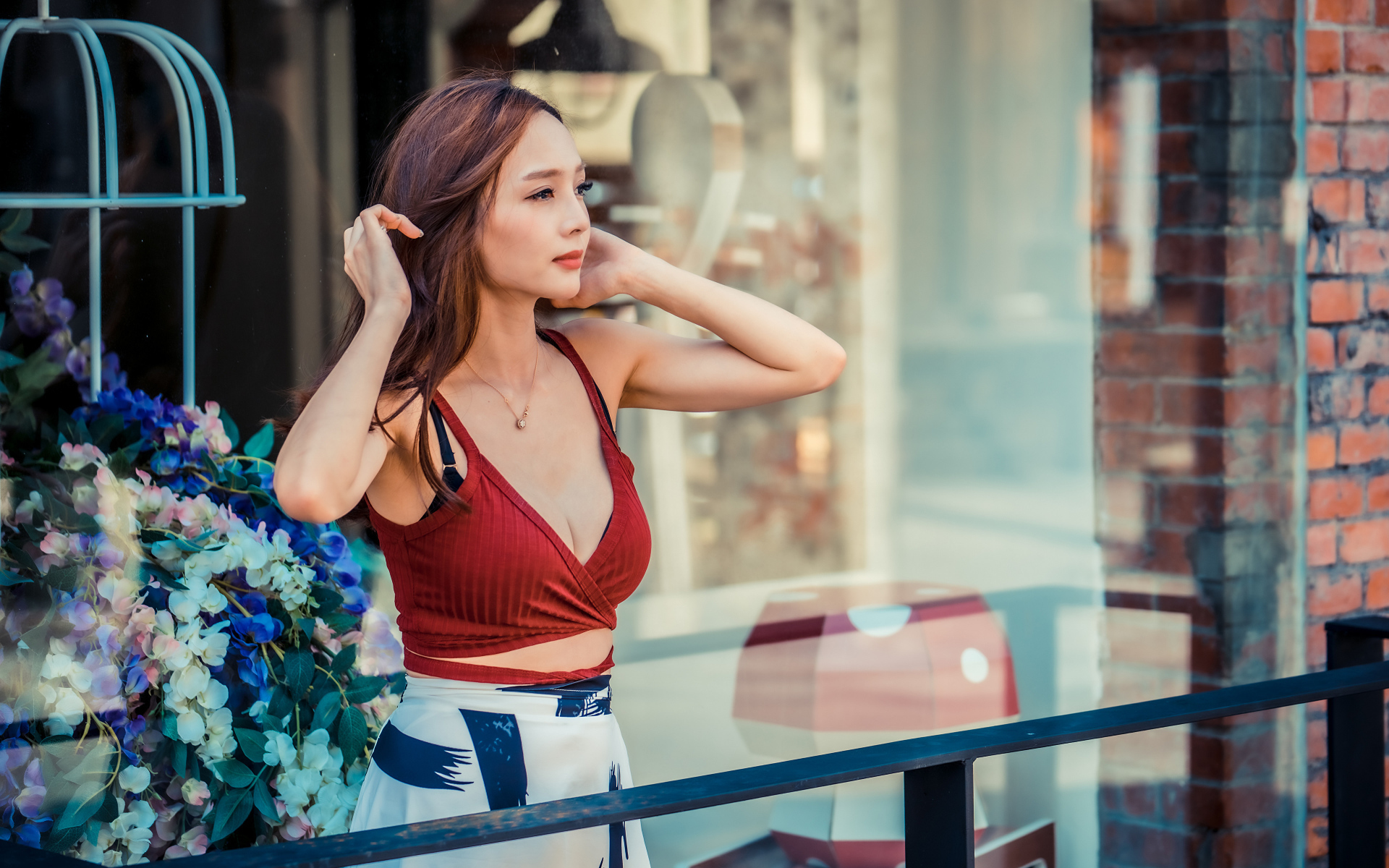 Нежная девушка азиатка стоит на балконе 