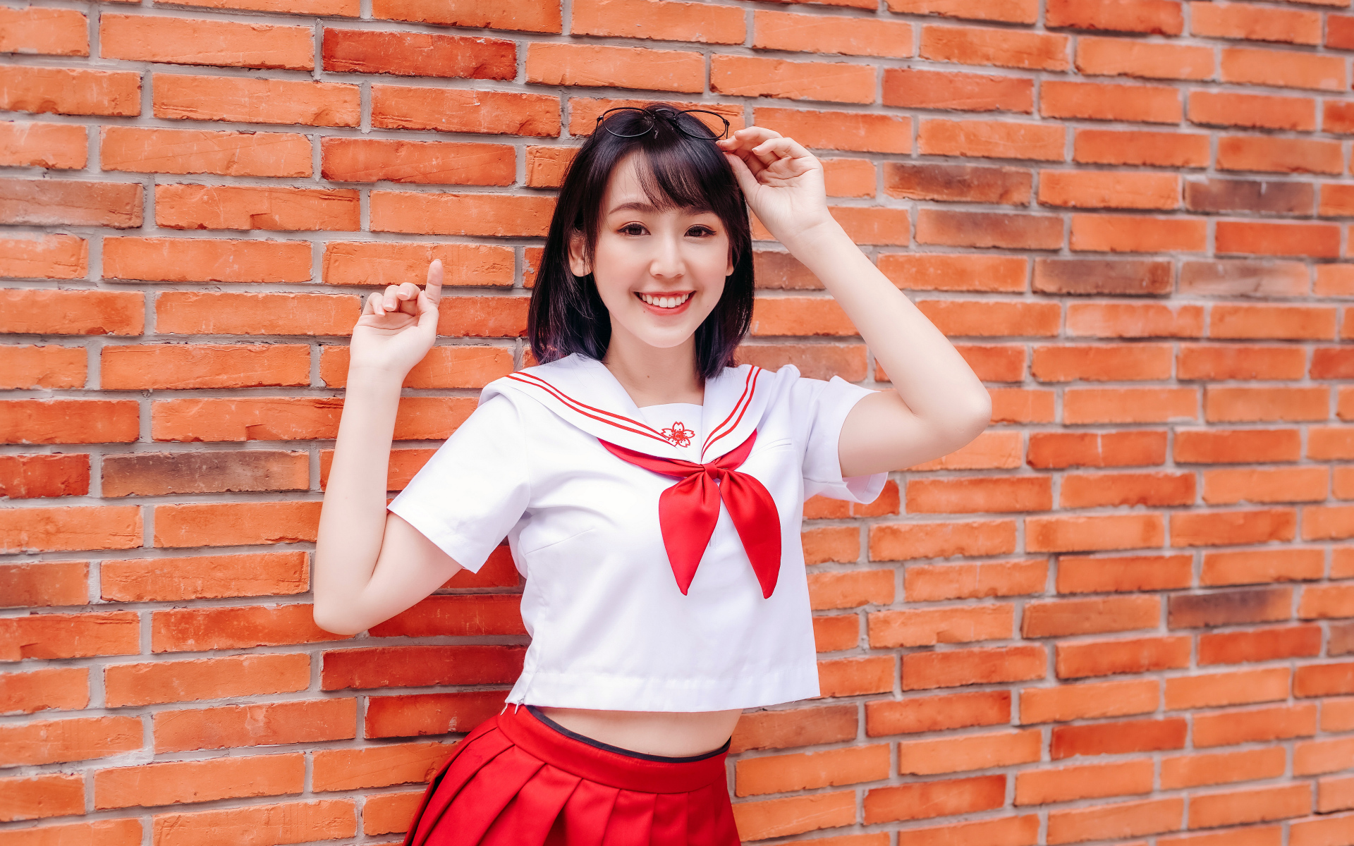 Улыбающаяся азиатка стоит у стены 