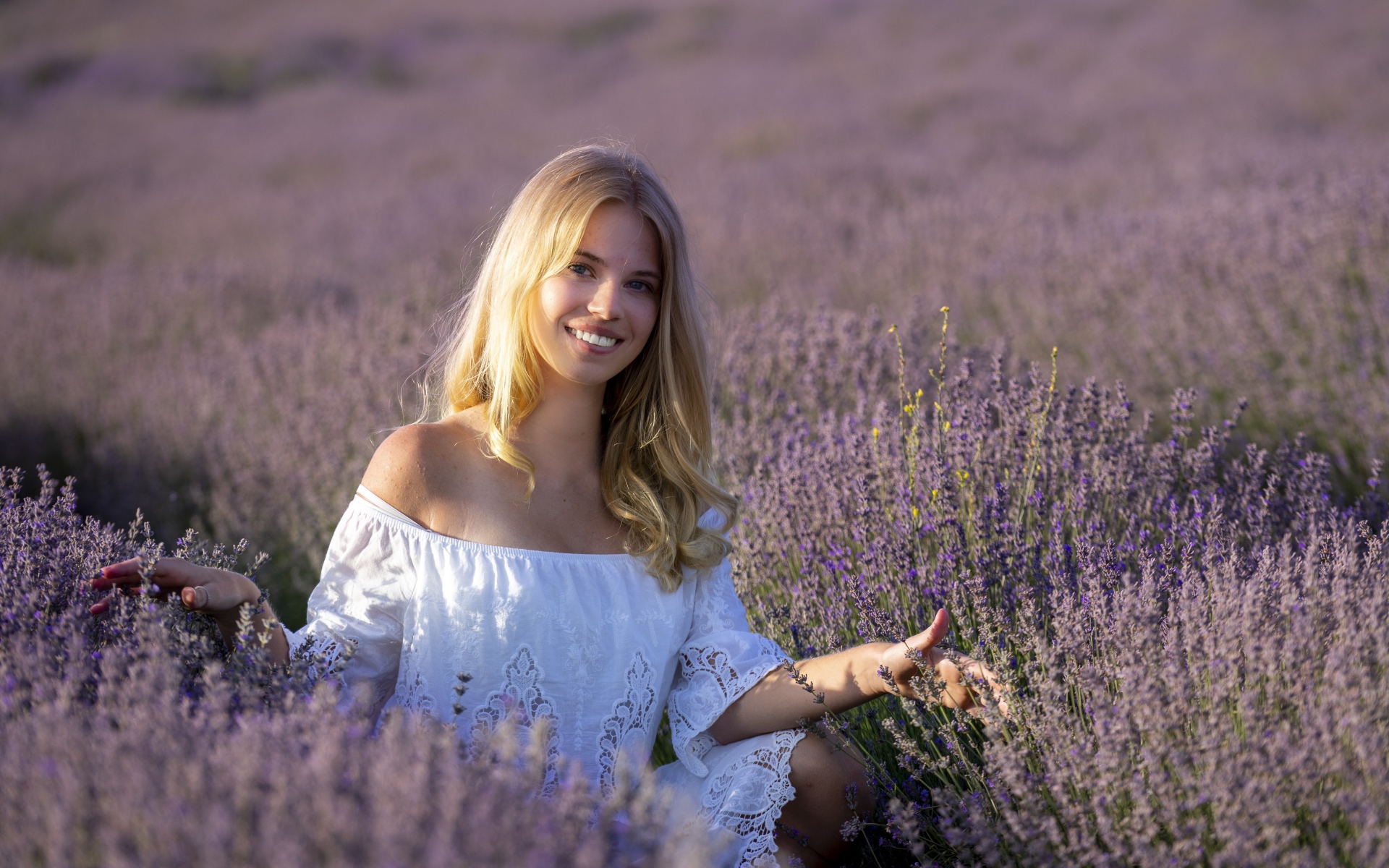Улыбающаяся девушка в белом платье на лавандовом поле 