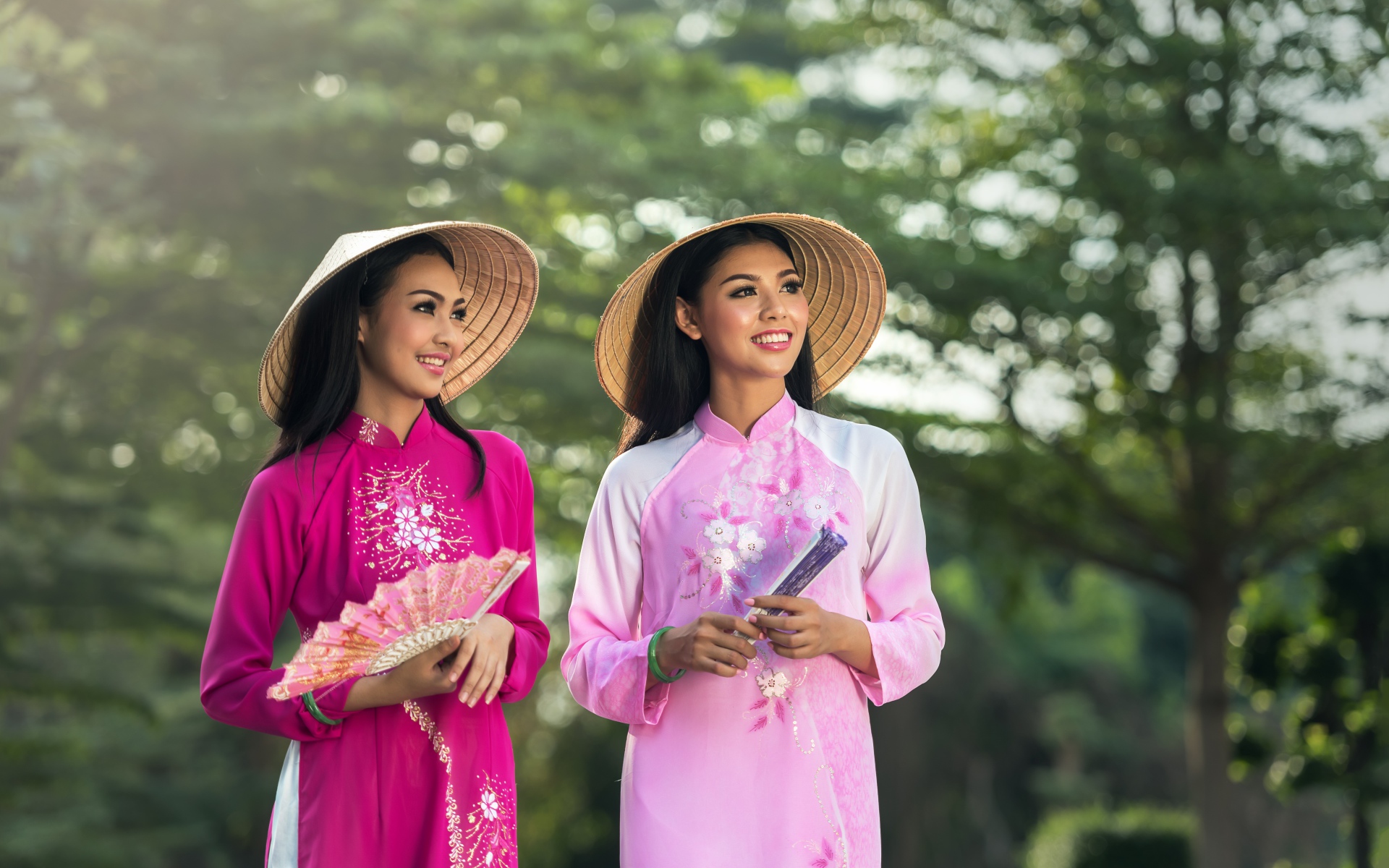 Две девушки азиатки в платьях с веером в руках