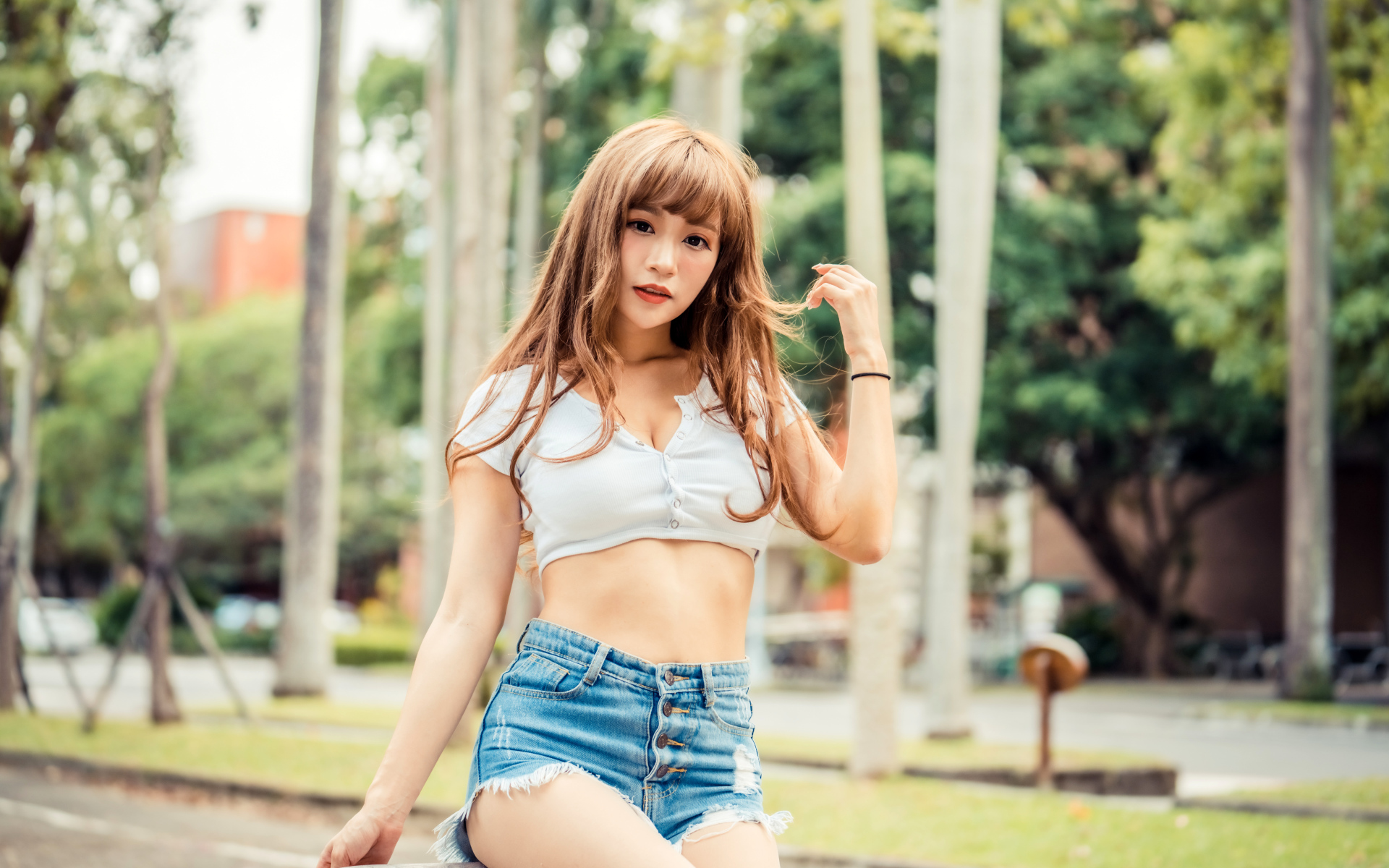 Молодая азиатка в коротком топе и синих шортах 