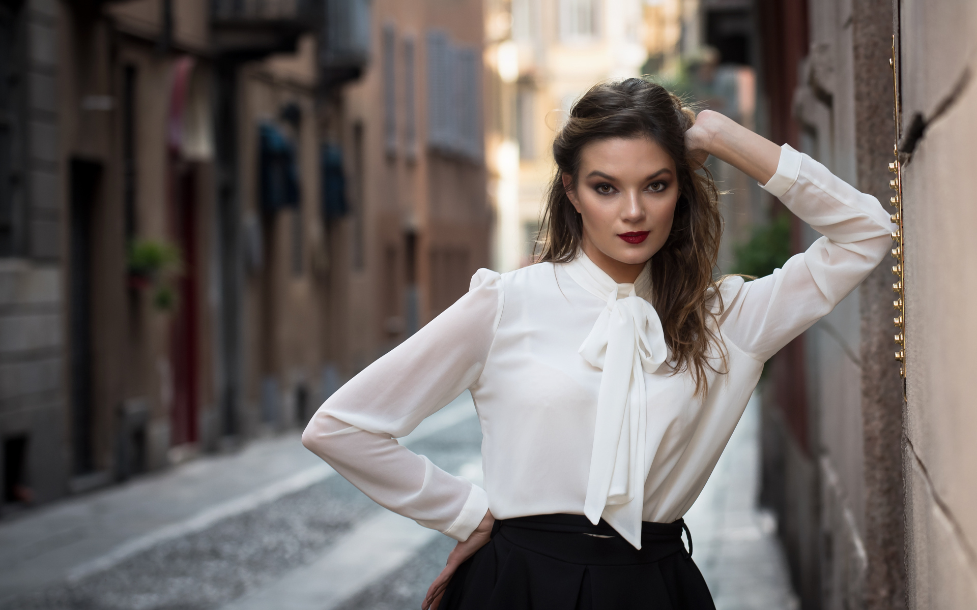 Молодая девушка в белой рубашке у стены