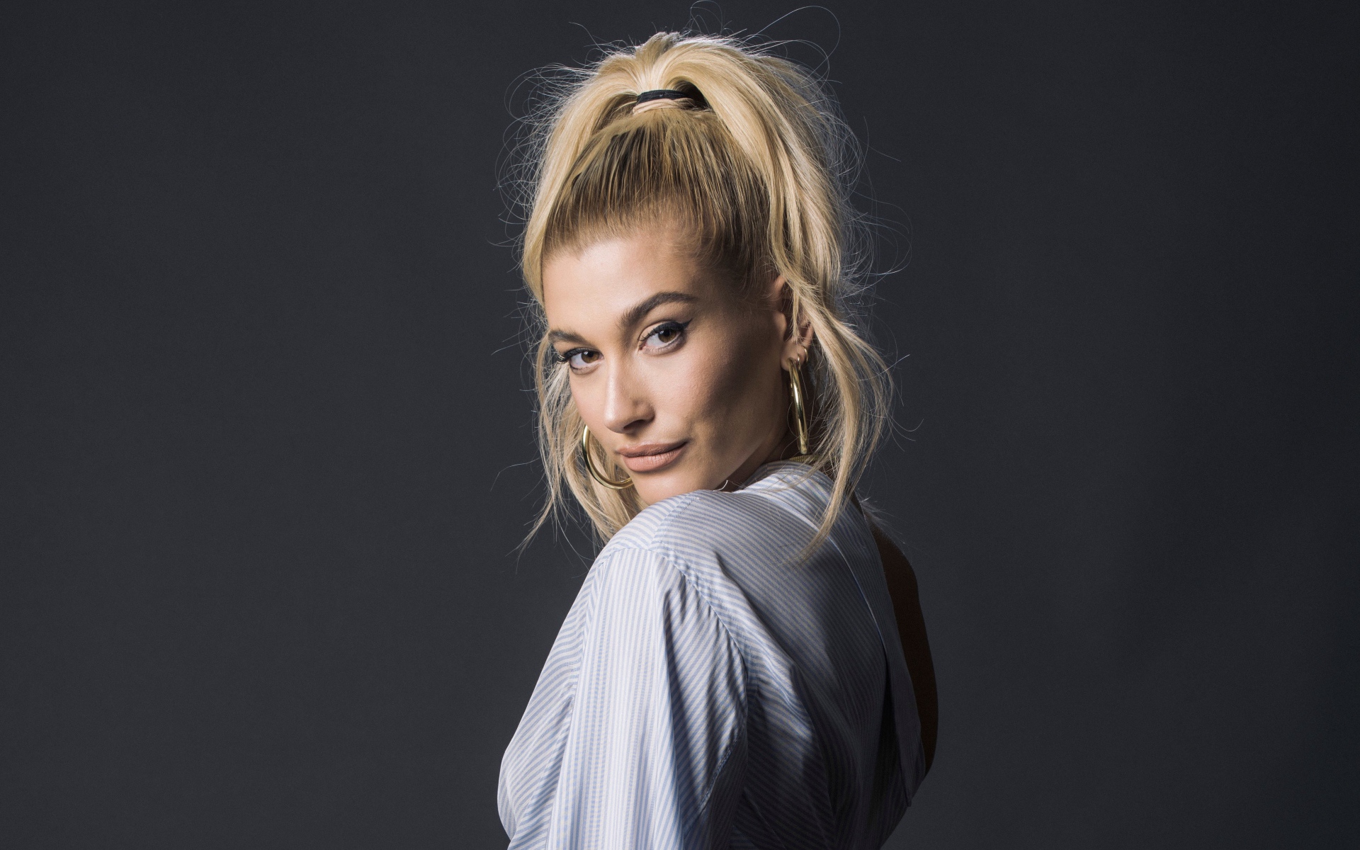 Красивая блондинка, американская модель Хейли Болдуин на сером фоне