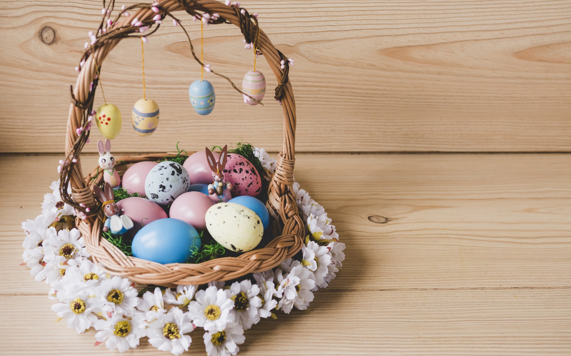 Корзинка с пасхальными яйцами украшена цветами
