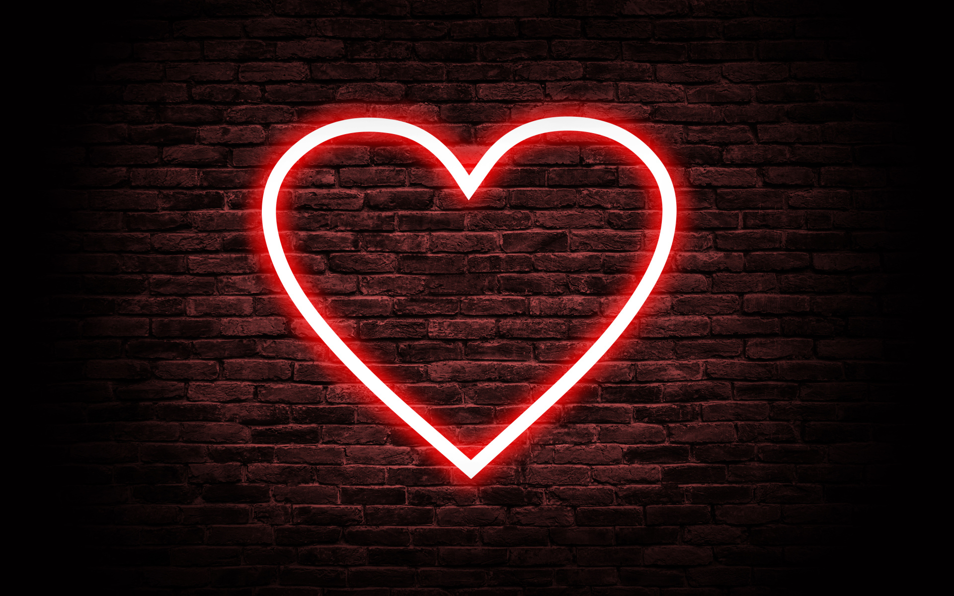 Красное неоновое сердце на кирпичной стене 