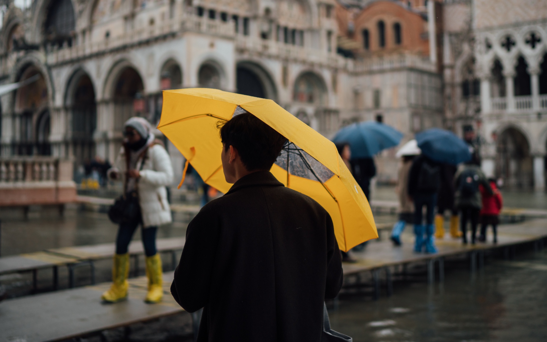 Мужчина с желтым зонтом в городе 