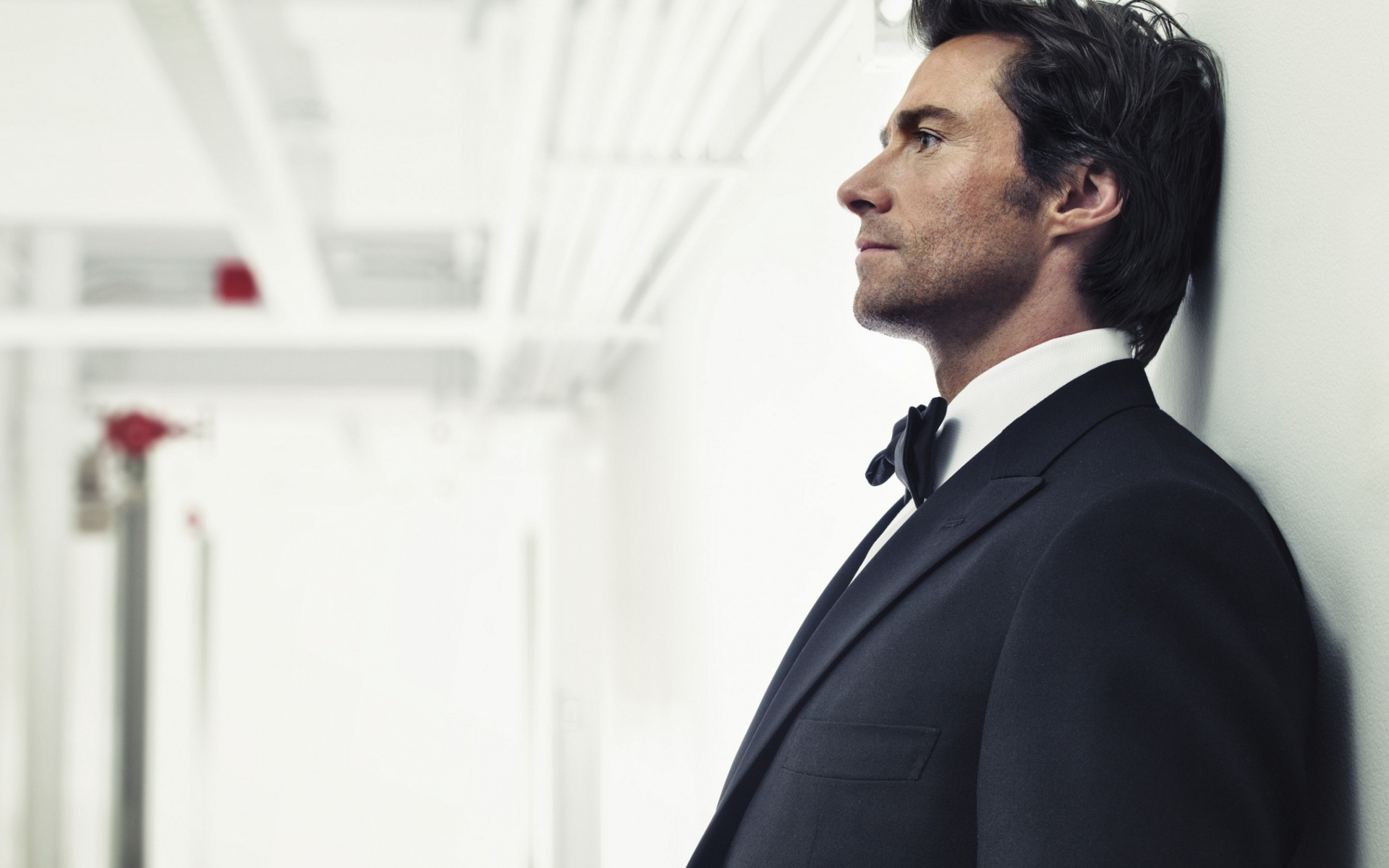 Мужчина в костюме, актер Хью Джекман у стены