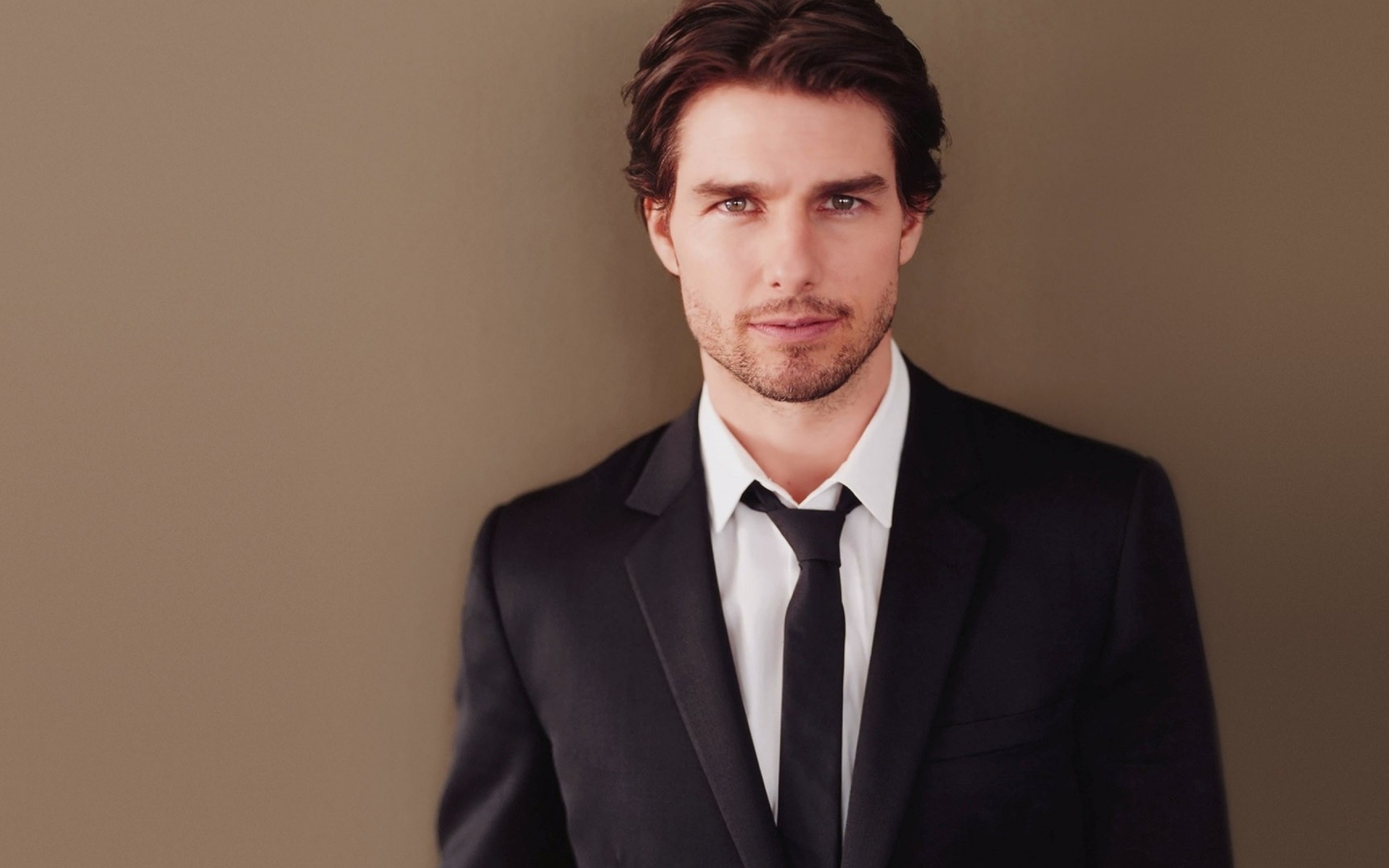 Популярный актер Том Круз в костюме на коричневом фоне