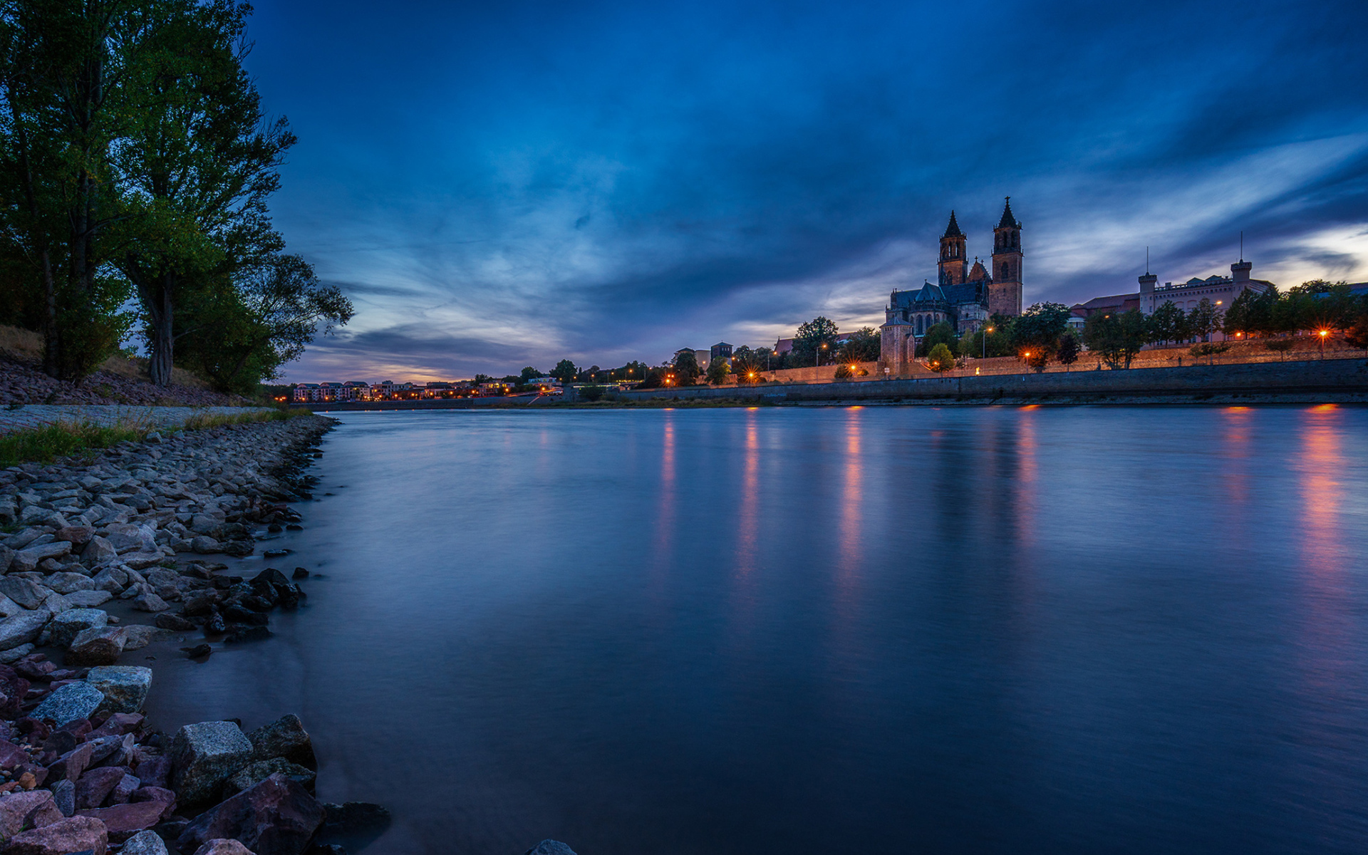 Замок у реки на фоне неба в сумерках 