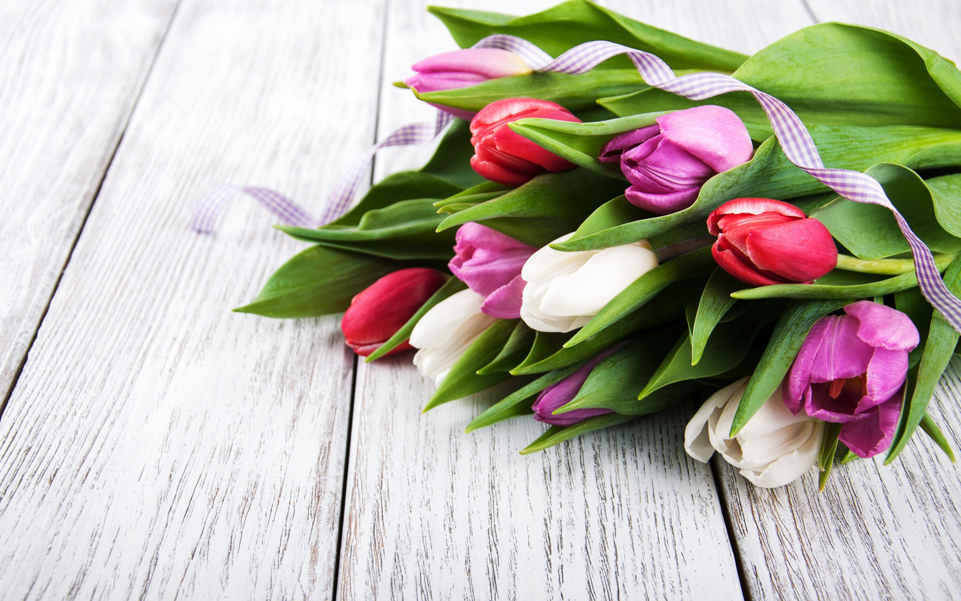 Букет свежих разноцветных тюльпанов на деревянном столе