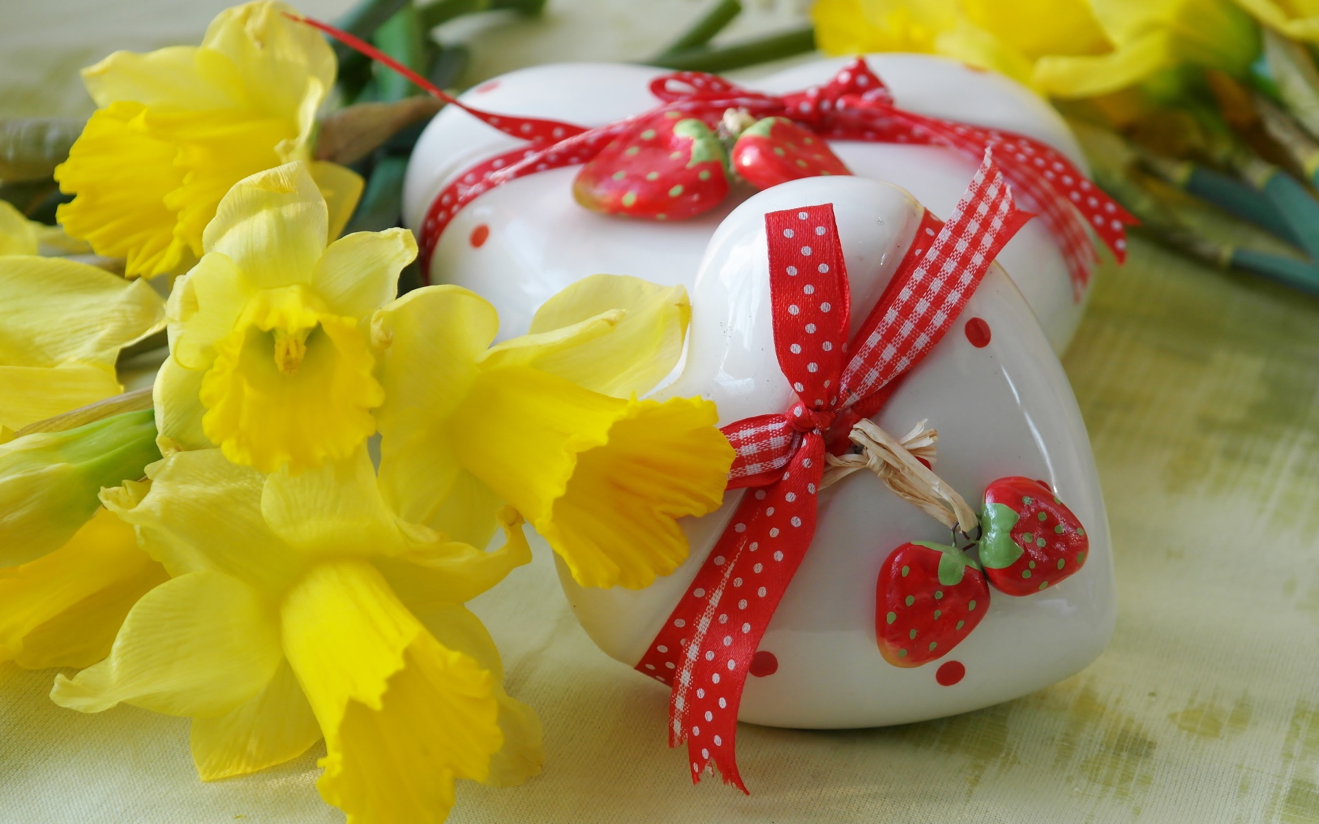 Два белых фарфоровых сердца с букетом желтых нарциссов