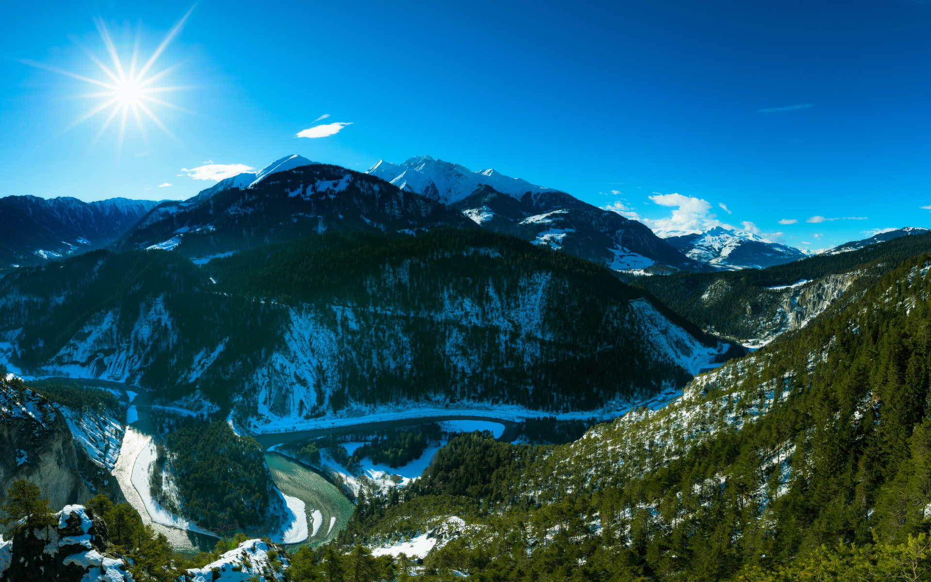 Яркое солнце в голубом небе над заснеженными горами, Швейцария 