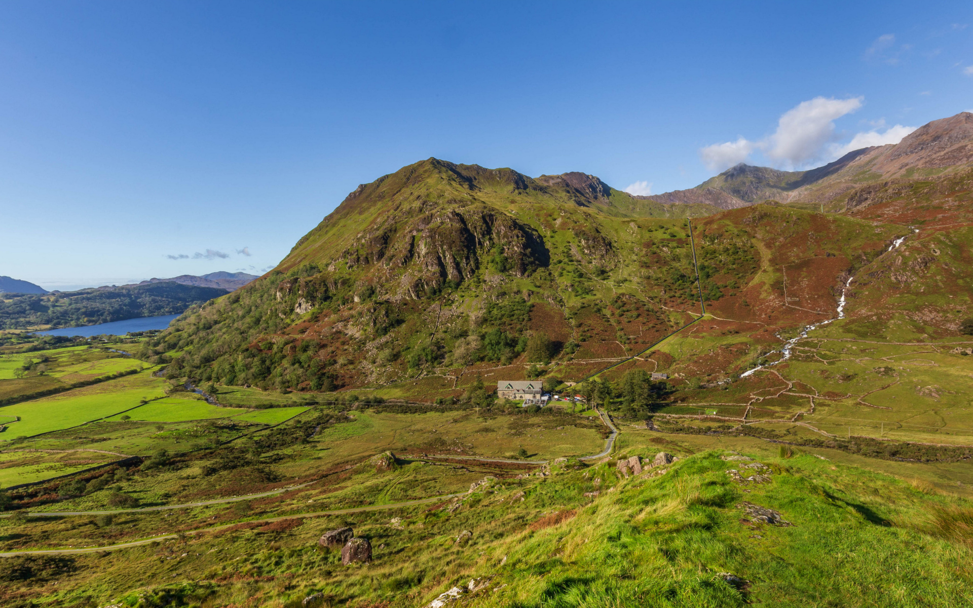Вид на покрытую зеленью гору под голубым небом
