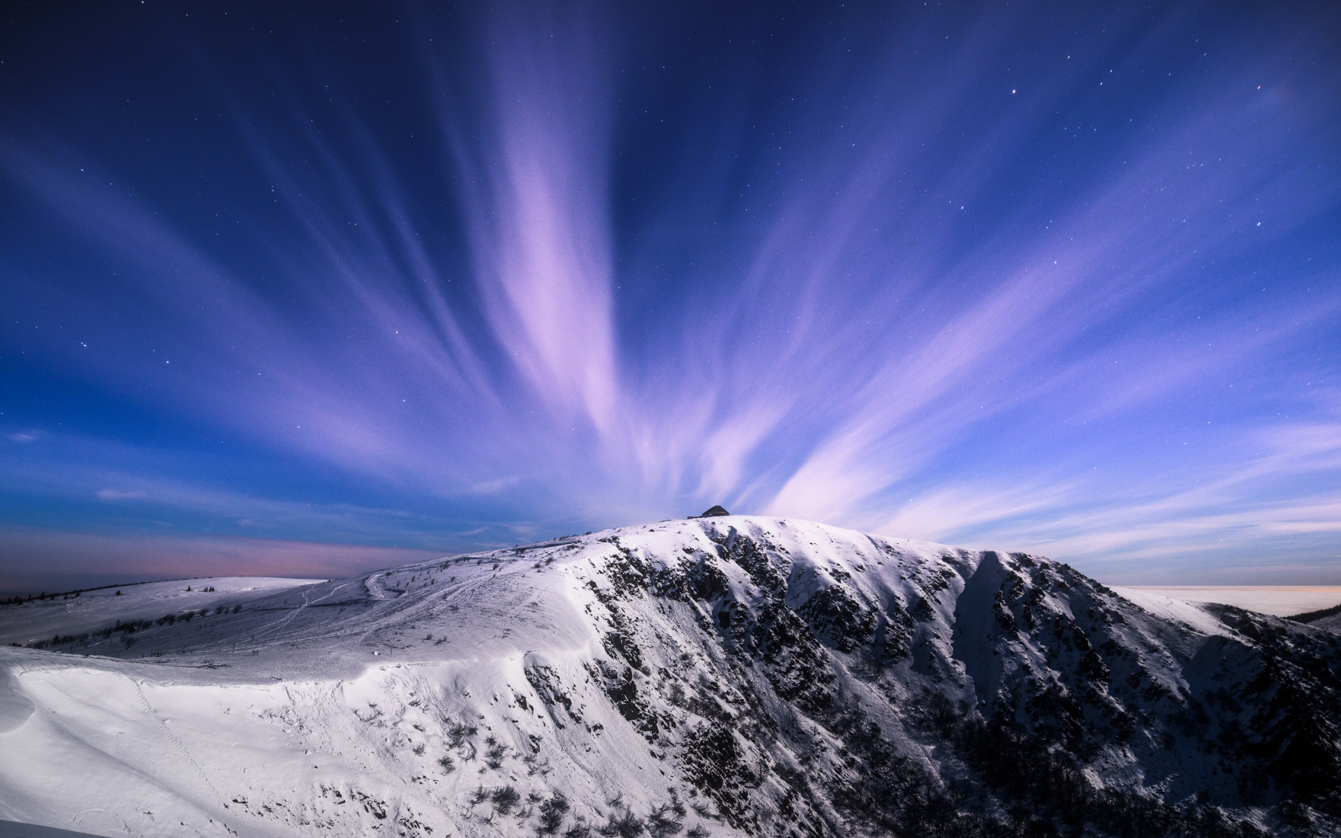Белые облака в голубом небе над заснеженными горами