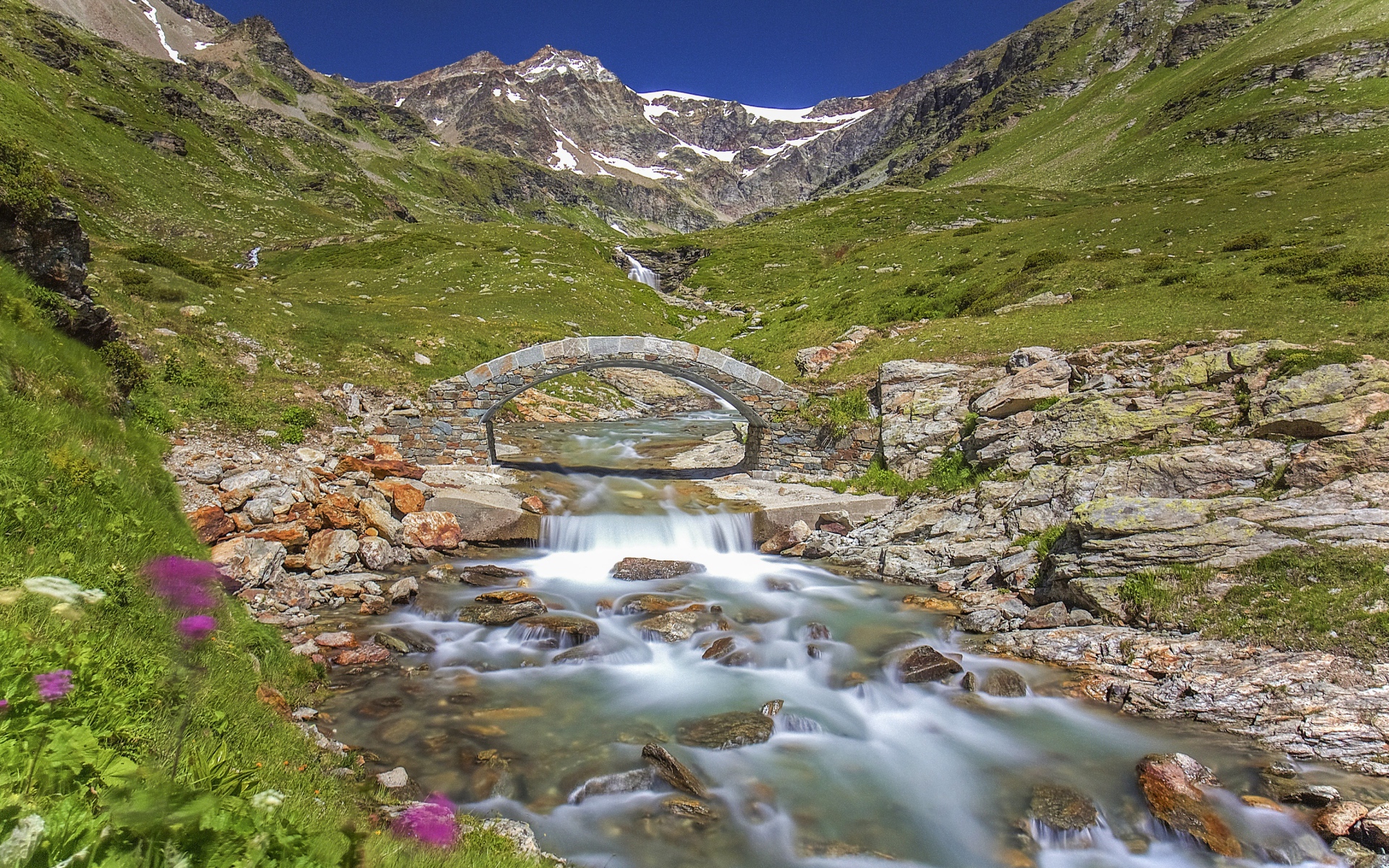 Маленький каменный мост через горную реку 