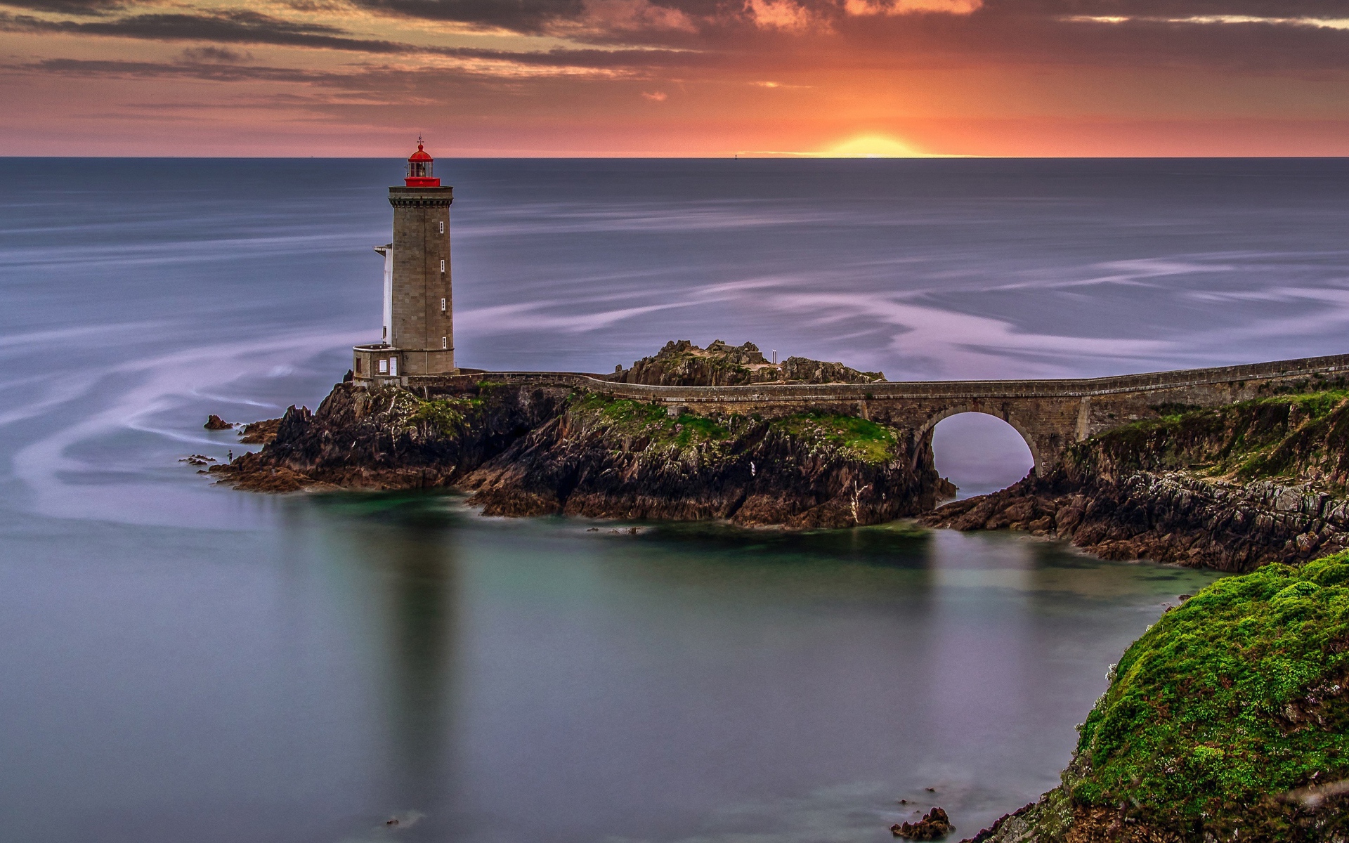 Вид на спокойное море и маяк на закате солнца 