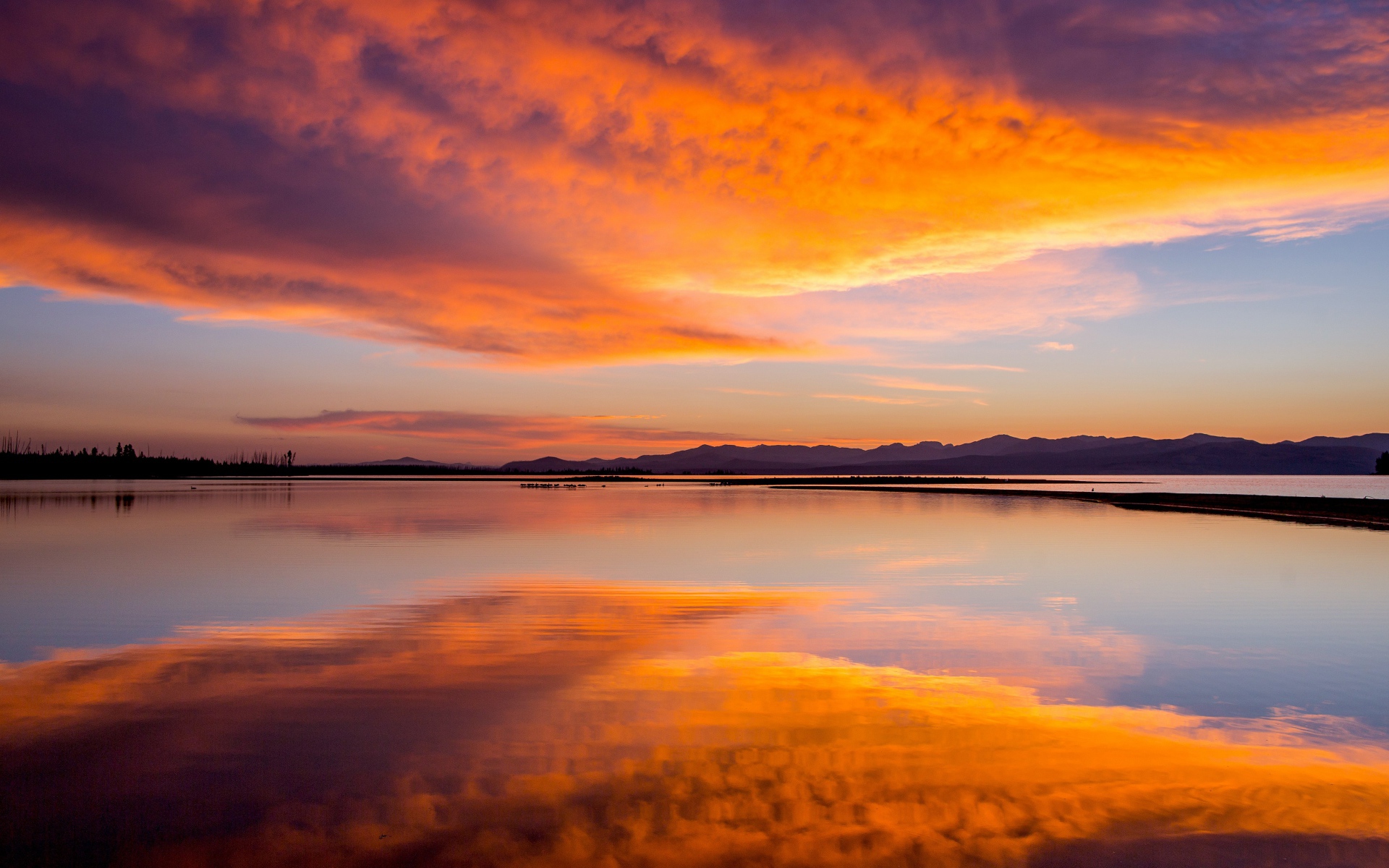 Красивое небо на закате отражается в спокойной воде озера