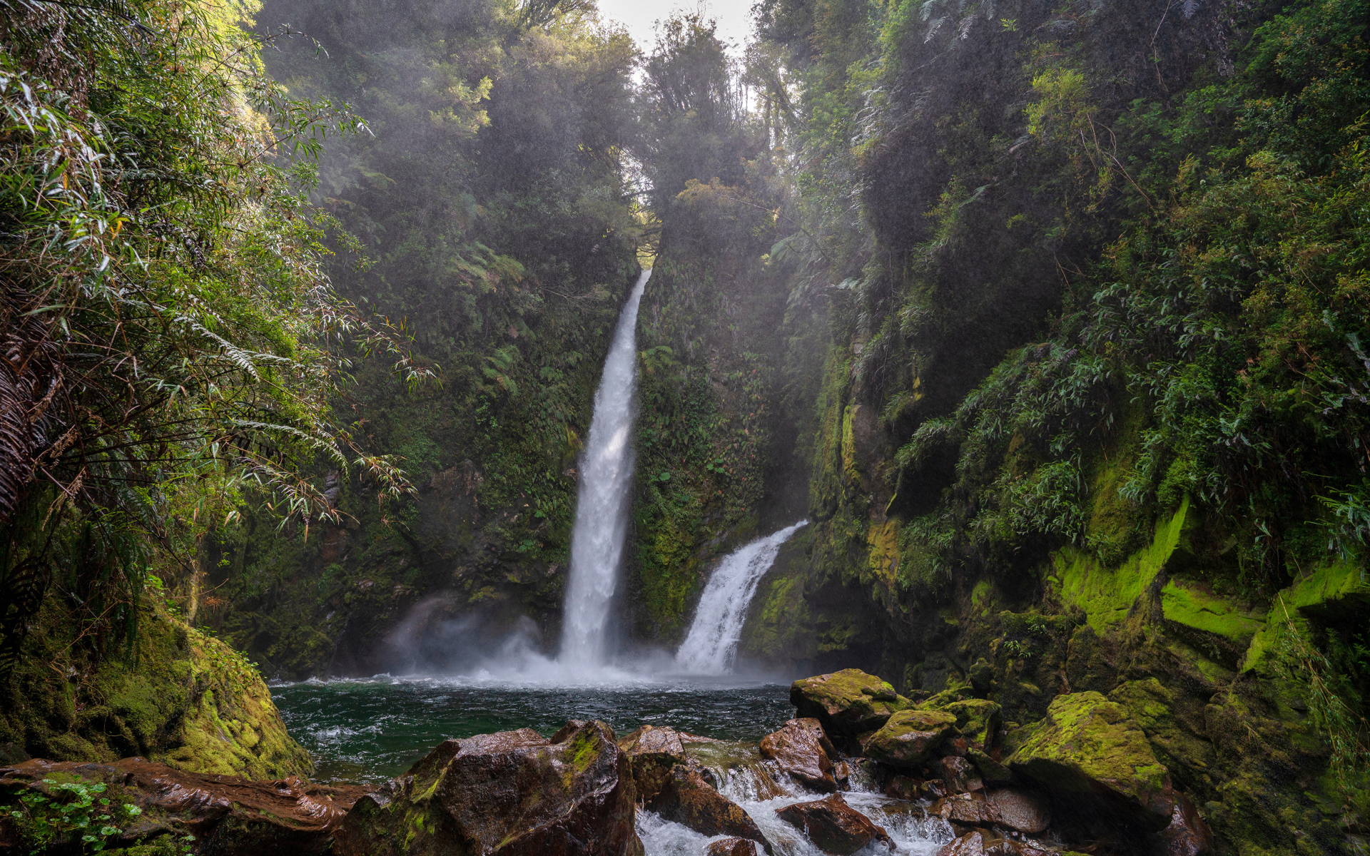 Водопад стекает со скалы в горную реку