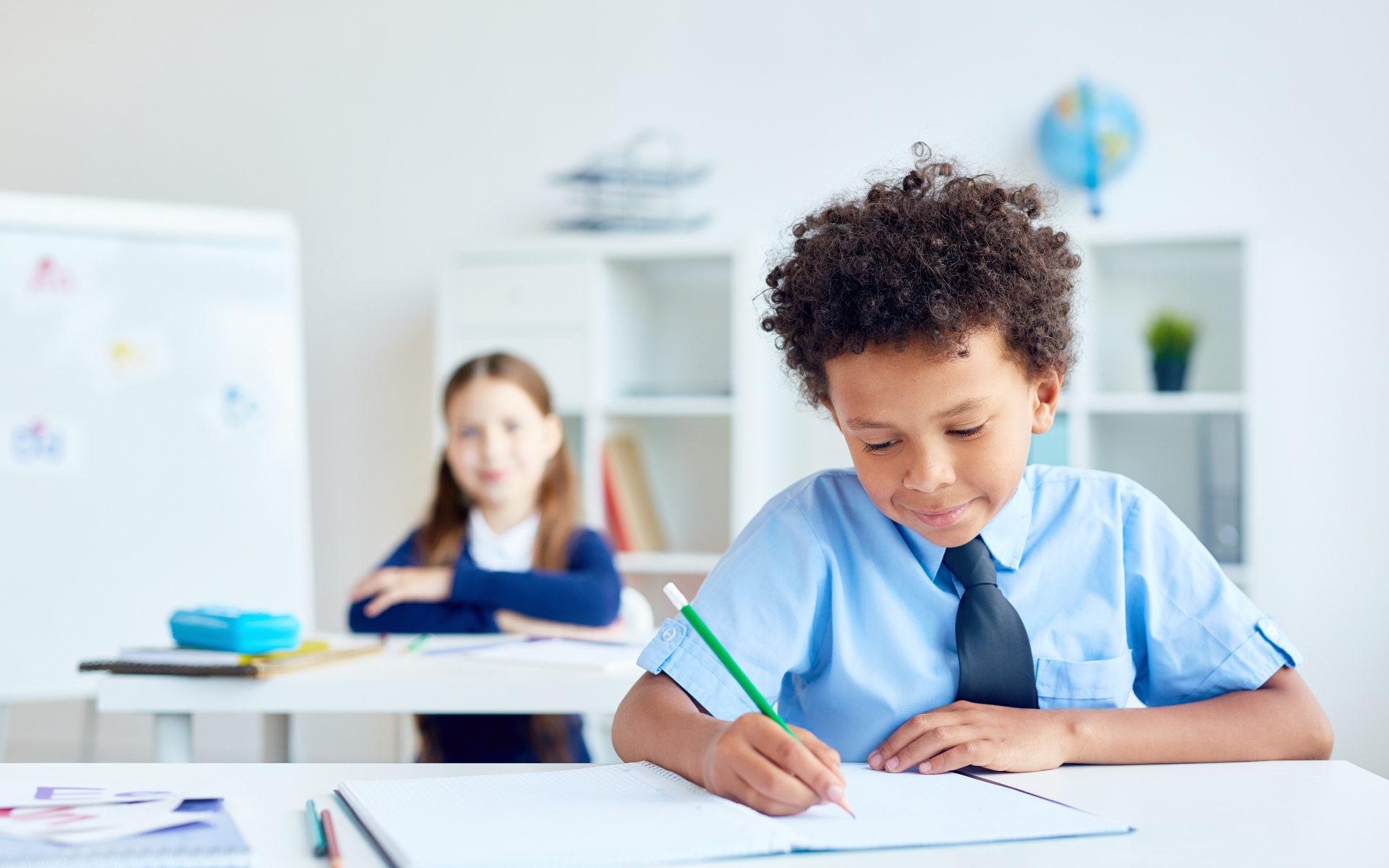 Маленький мальчик сидит за партой в классе