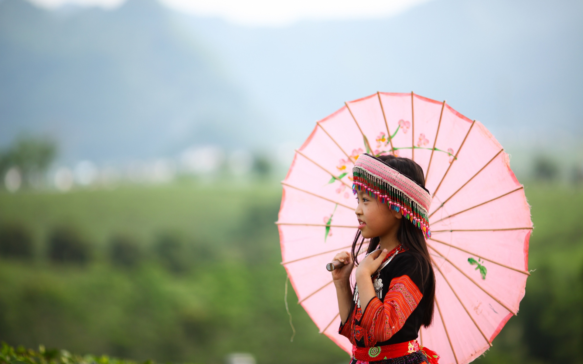 Маленькая девочка азиатка в розовым зонтом