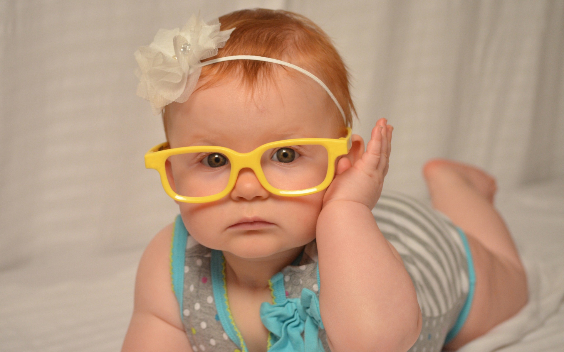 Маленькая красивая девочка в очках с обручем на голове